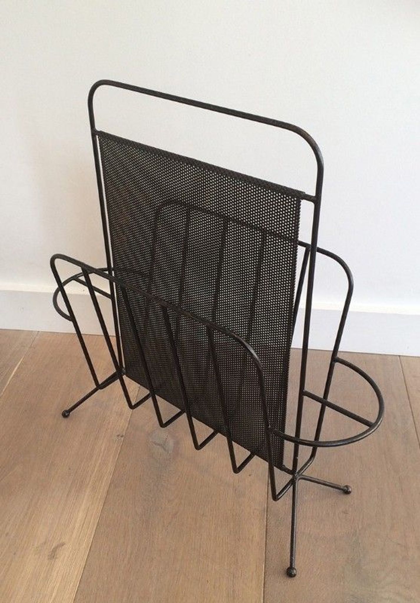 Black lacquered metal and perforated metal magazine rack designed by Mathieu Matégot 50.