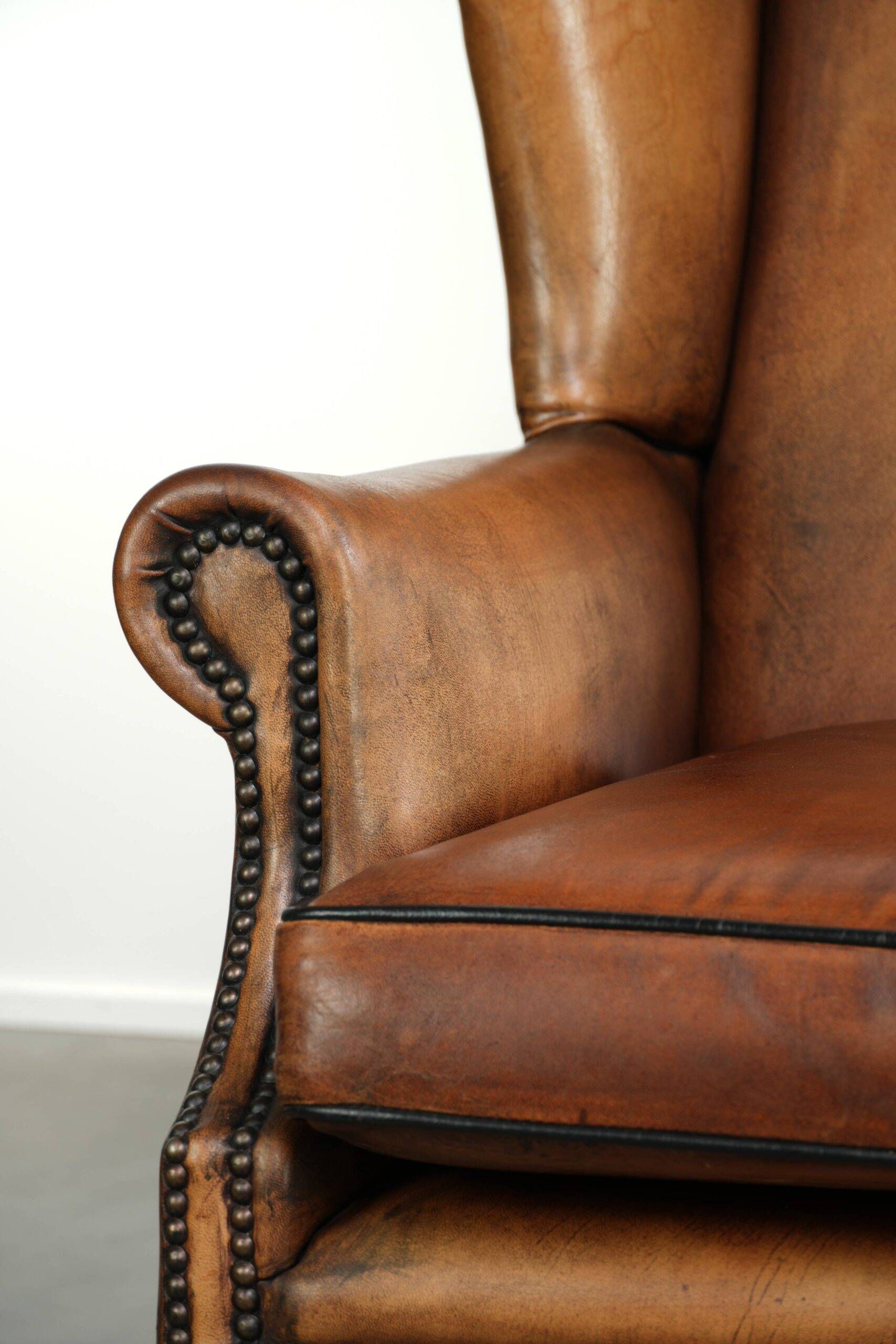 Sheepskin wingback armchair with patina finished with decorative nails