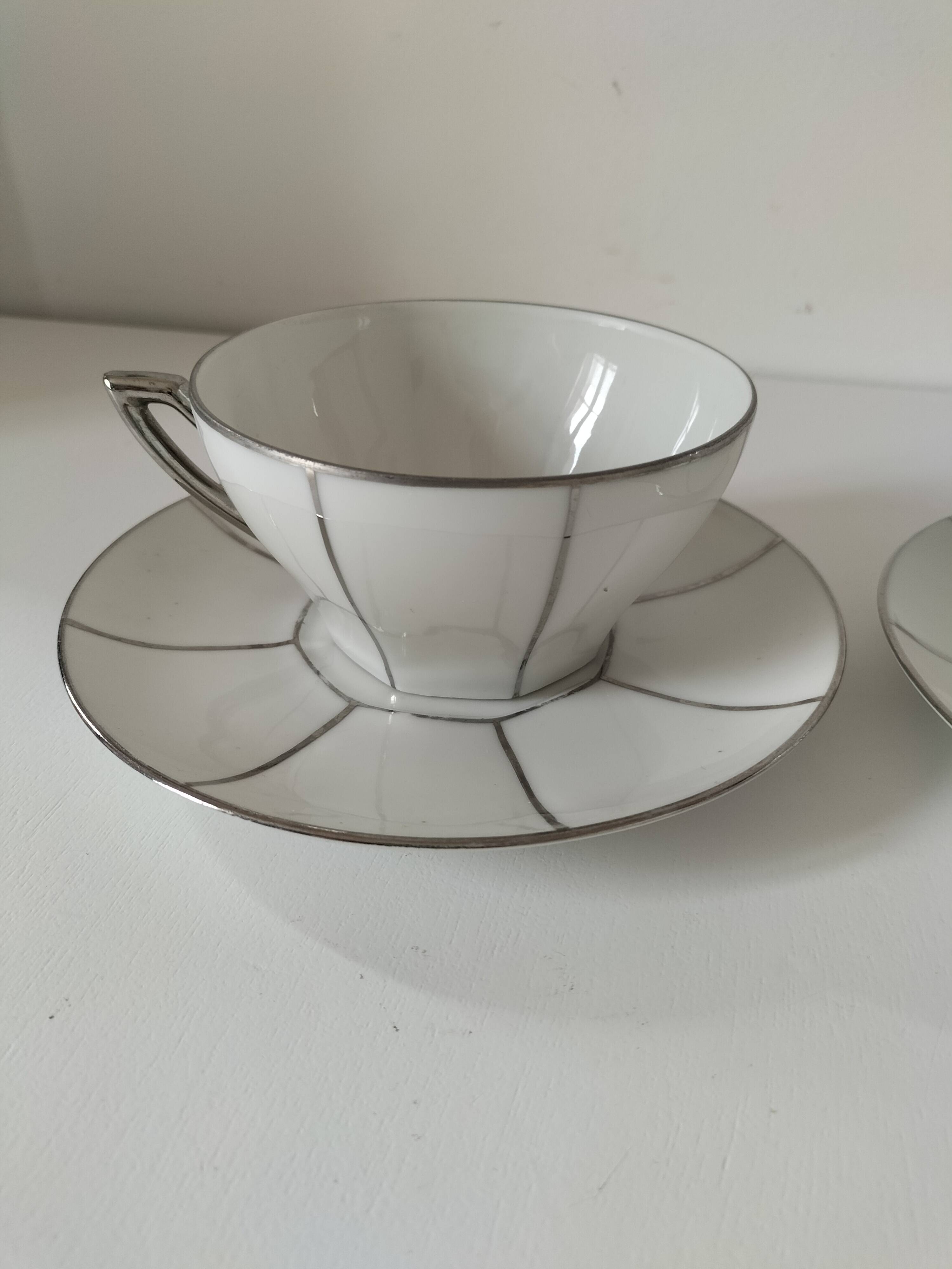 Two Art Deco porcelain cups and saucers with silver trim.