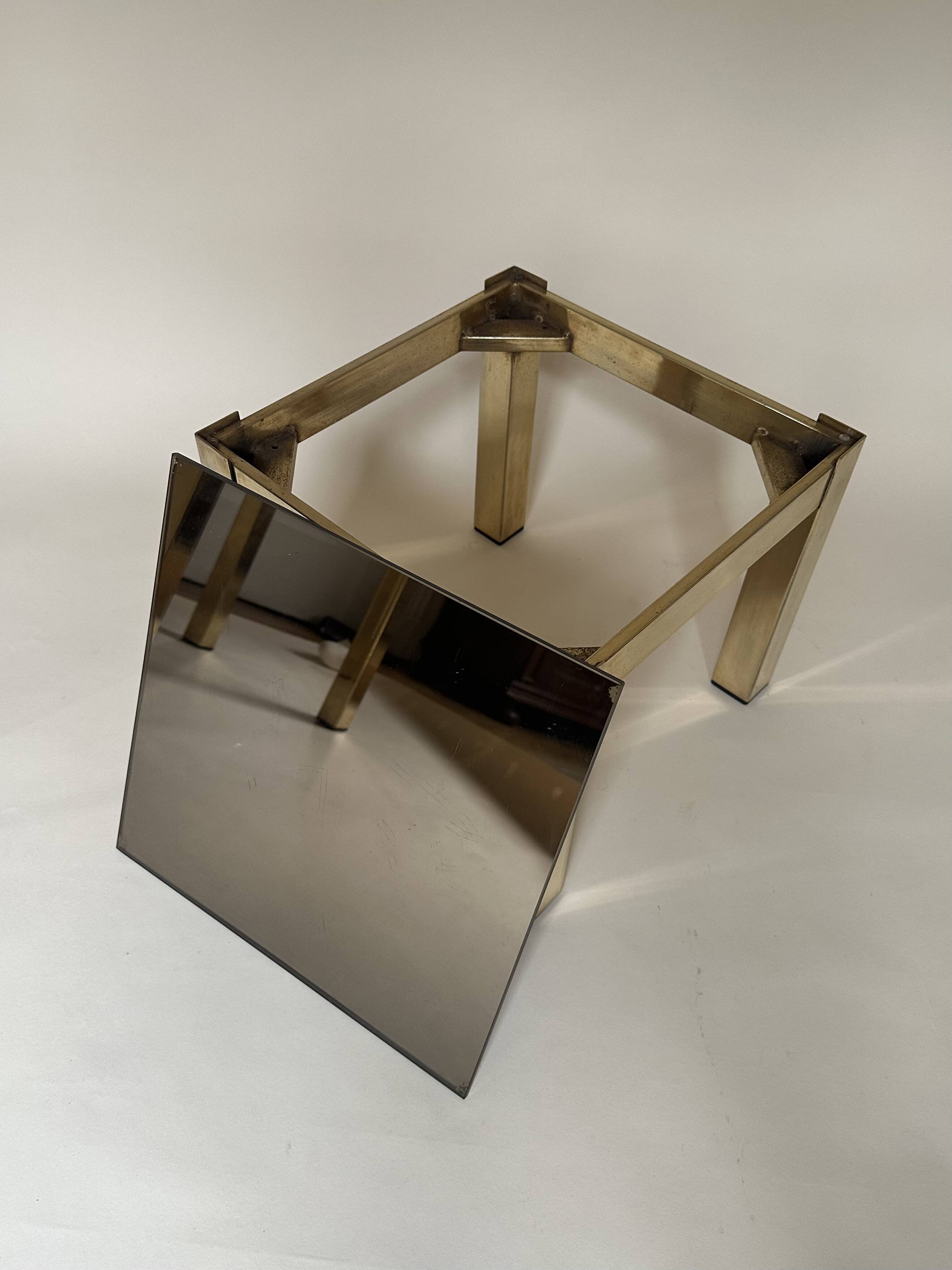Set of three nesting side tables in brass and smoked mirror.