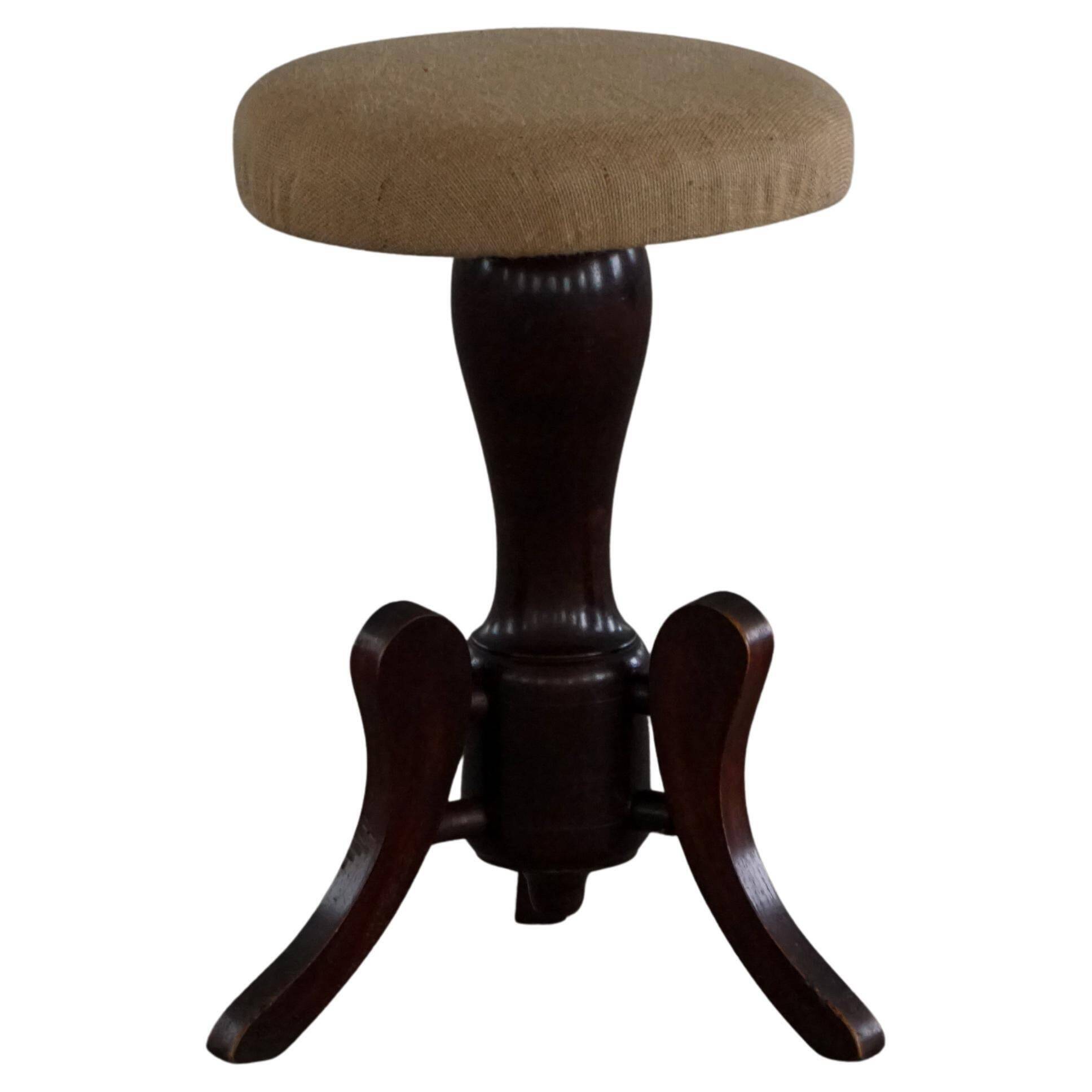 Adjustable Victorian-style piano stool with a jute fabric seat, early 20th century.