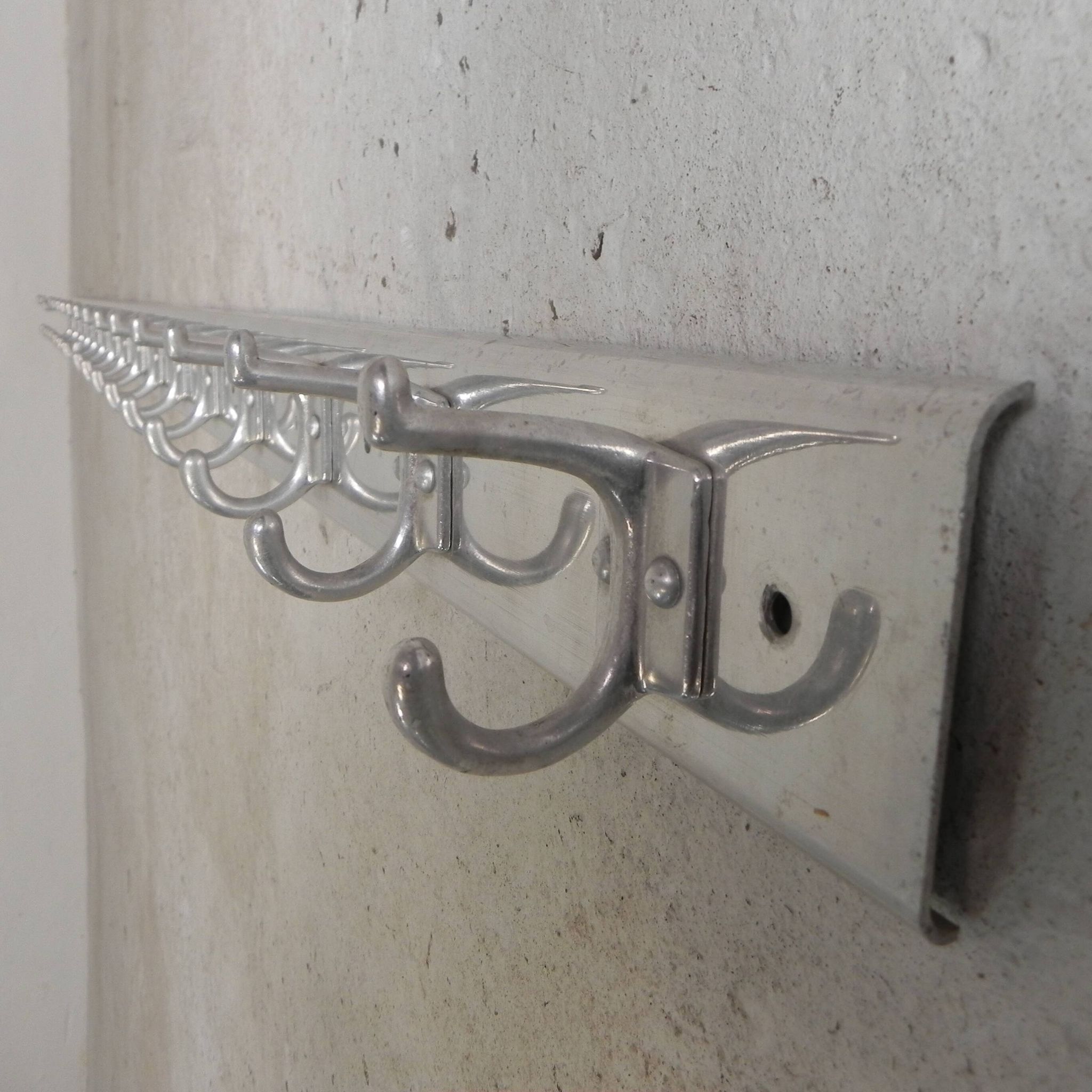 Wall-mounted aluminium coat rack of 225 cm with 16 double hooks, 1960s.