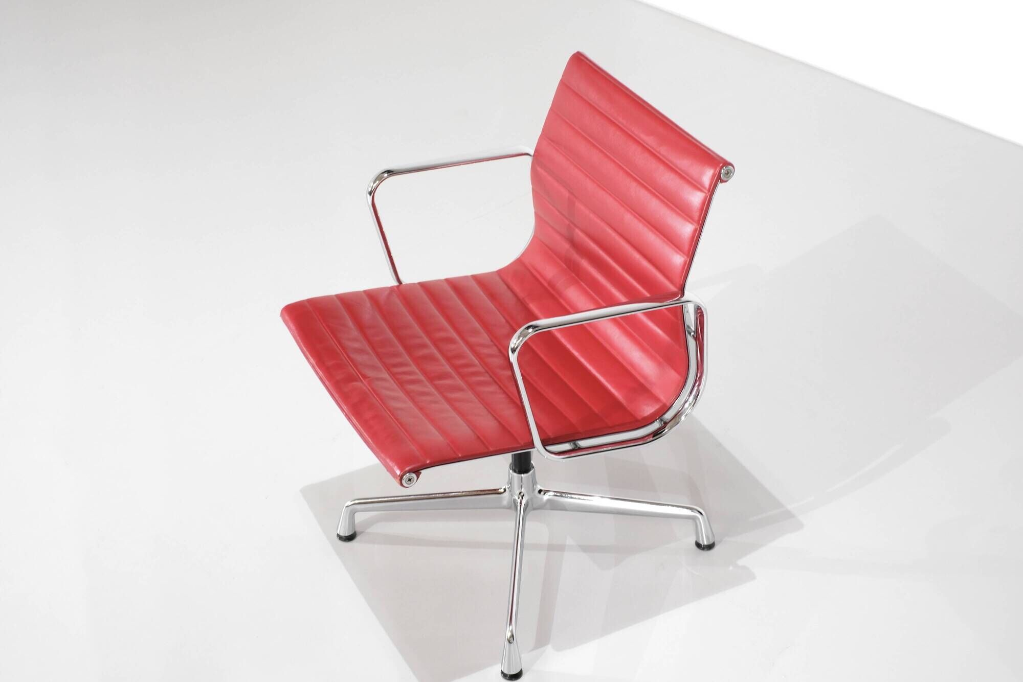 "EA 108" armchair in red leather, designed by Charles and Ray Eames for Vitra,