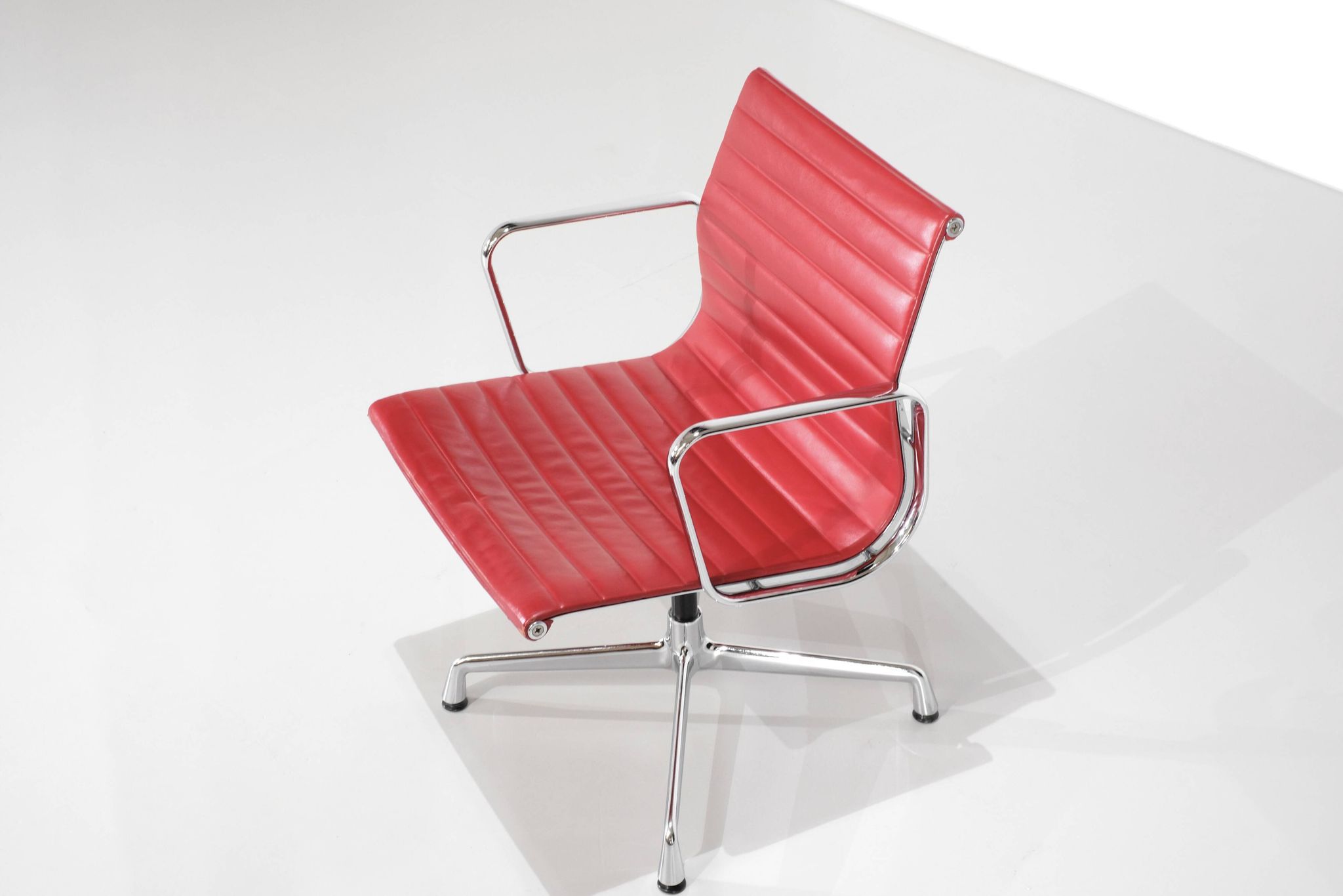 Fauteuil " EA 108 " en cuir rouge, conçu par Charles Ray Eames pour Vitra,
