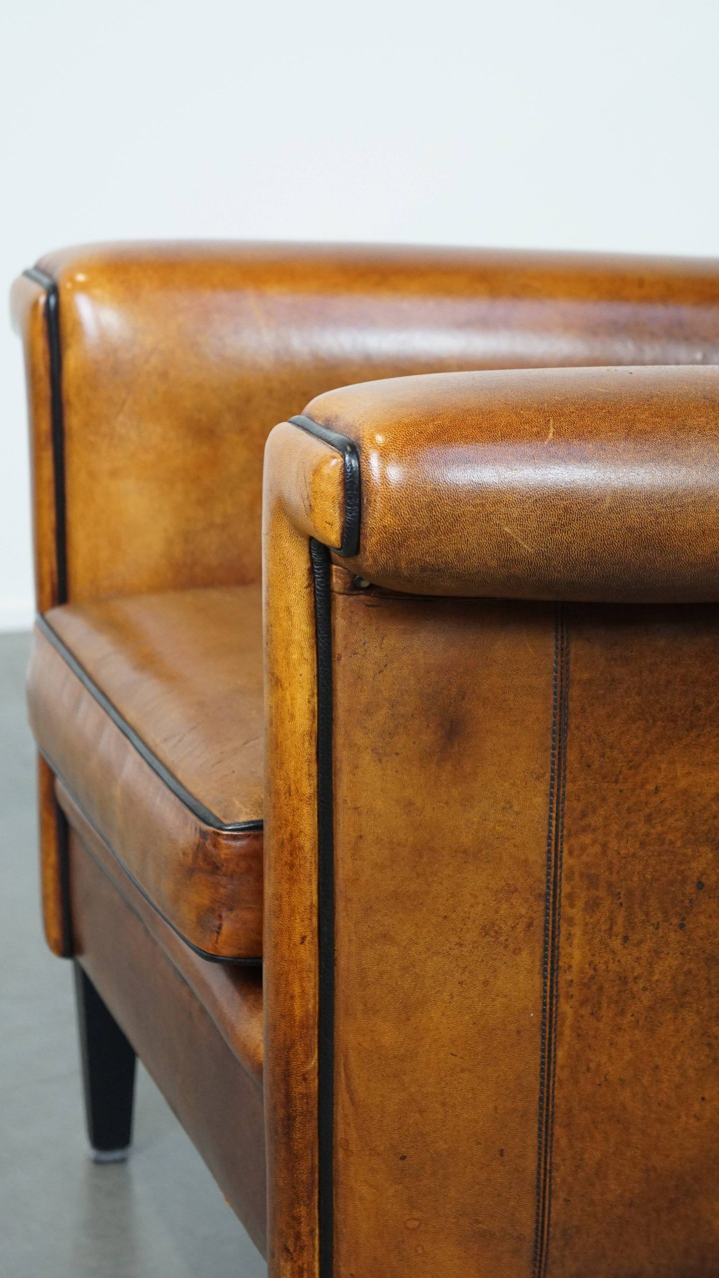 Sheepskin Art Deco design armchair with sleek finish and black piping