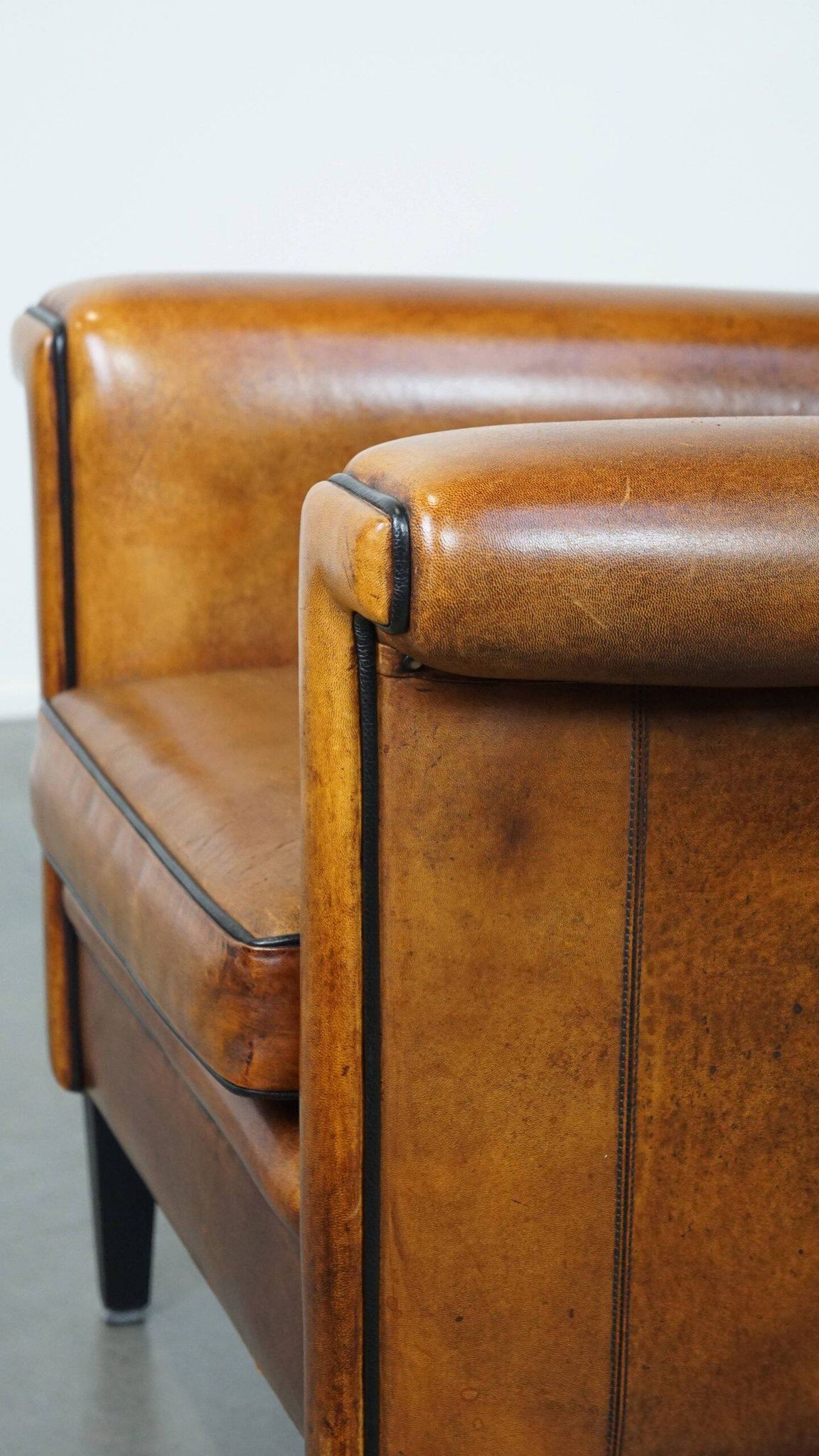 Sheepskin Art Deco design armchair with sleek finish and black piping