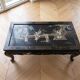 Table basse chinoise en bois laqué noir et décor doré