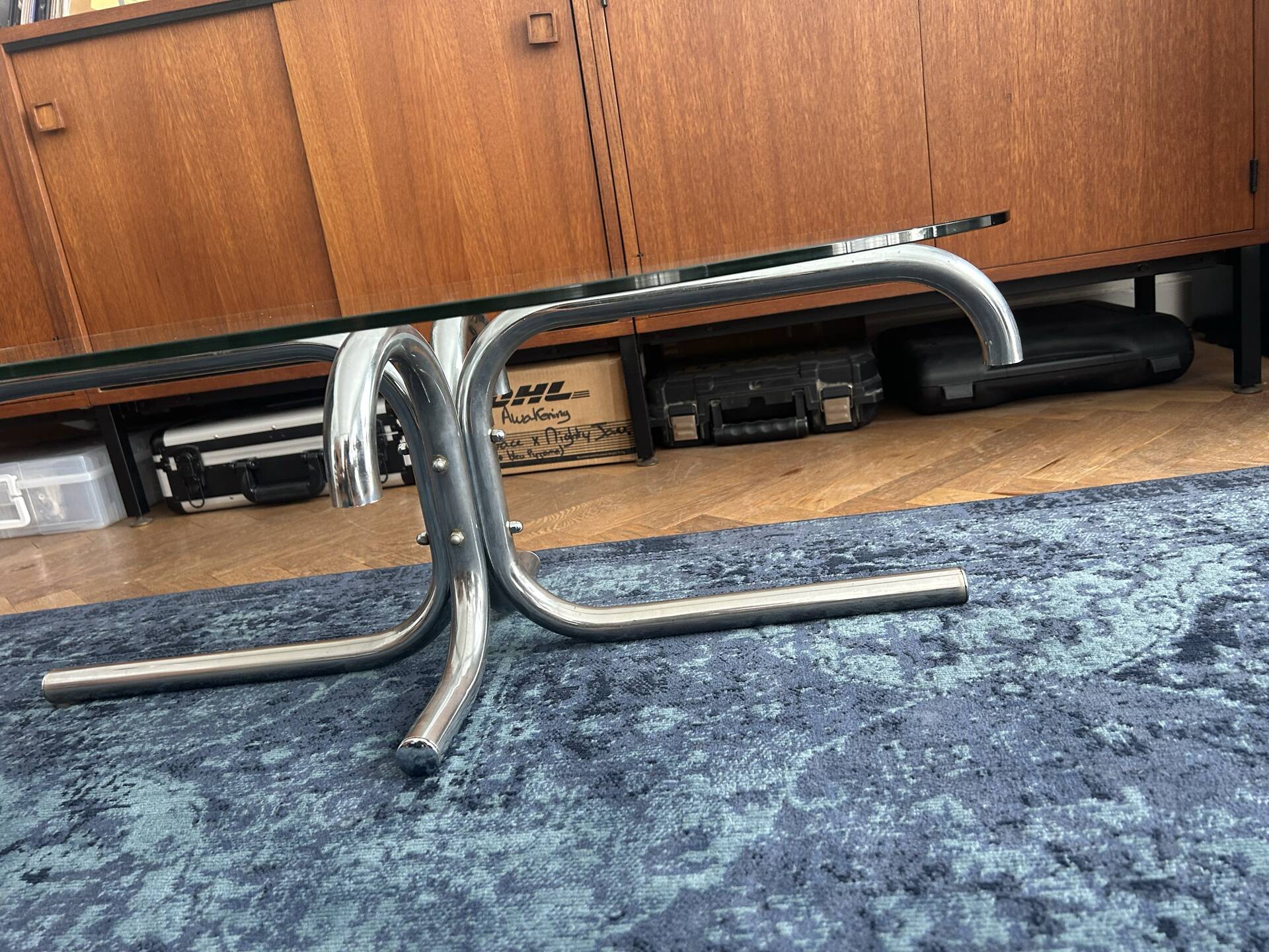 Oval glass coffee table with chrome legs, vintage 70s design.
