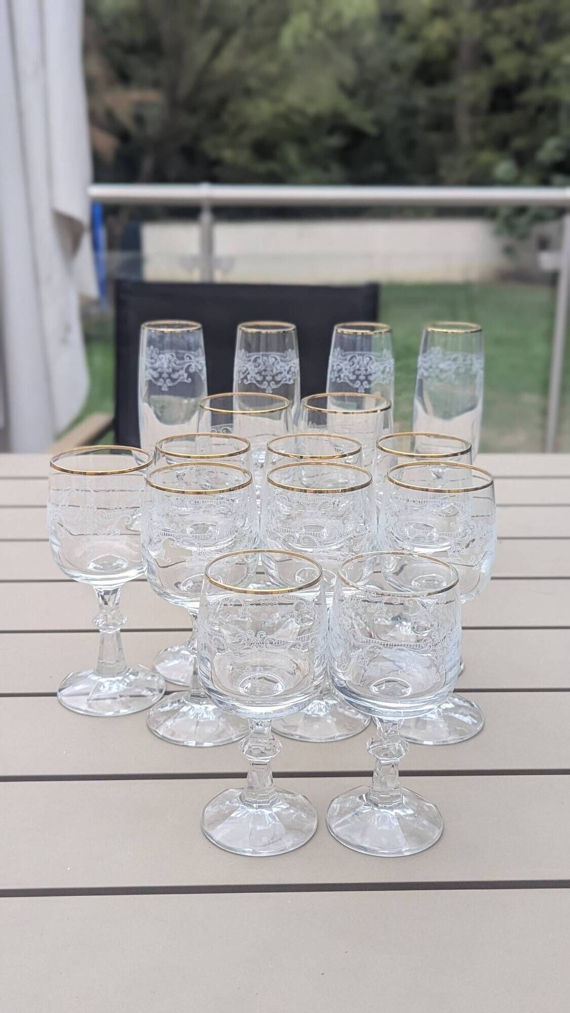 Set of 15 engraved crystal glasses with a gold rim.