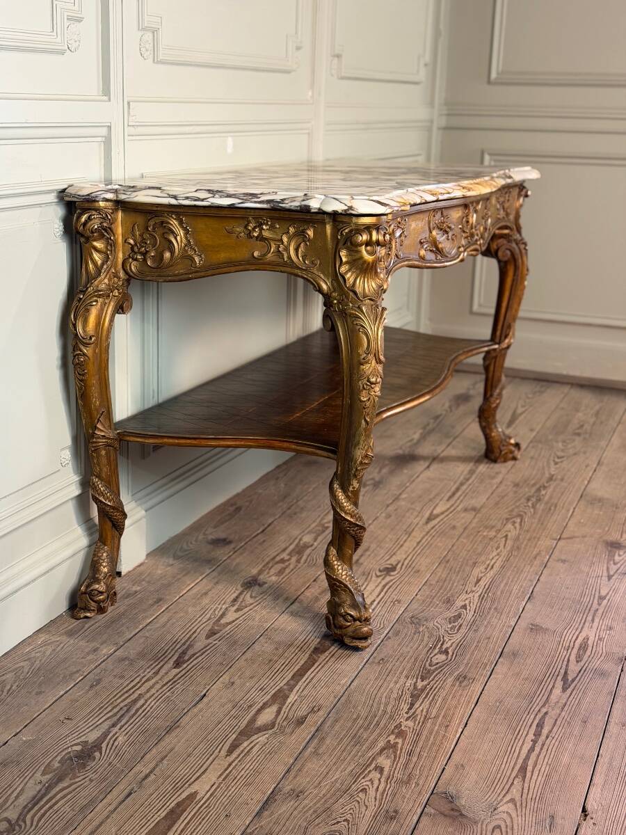 Golden wooden console, four legs adorned with sea monsters, purple breccia marble, around 1900.