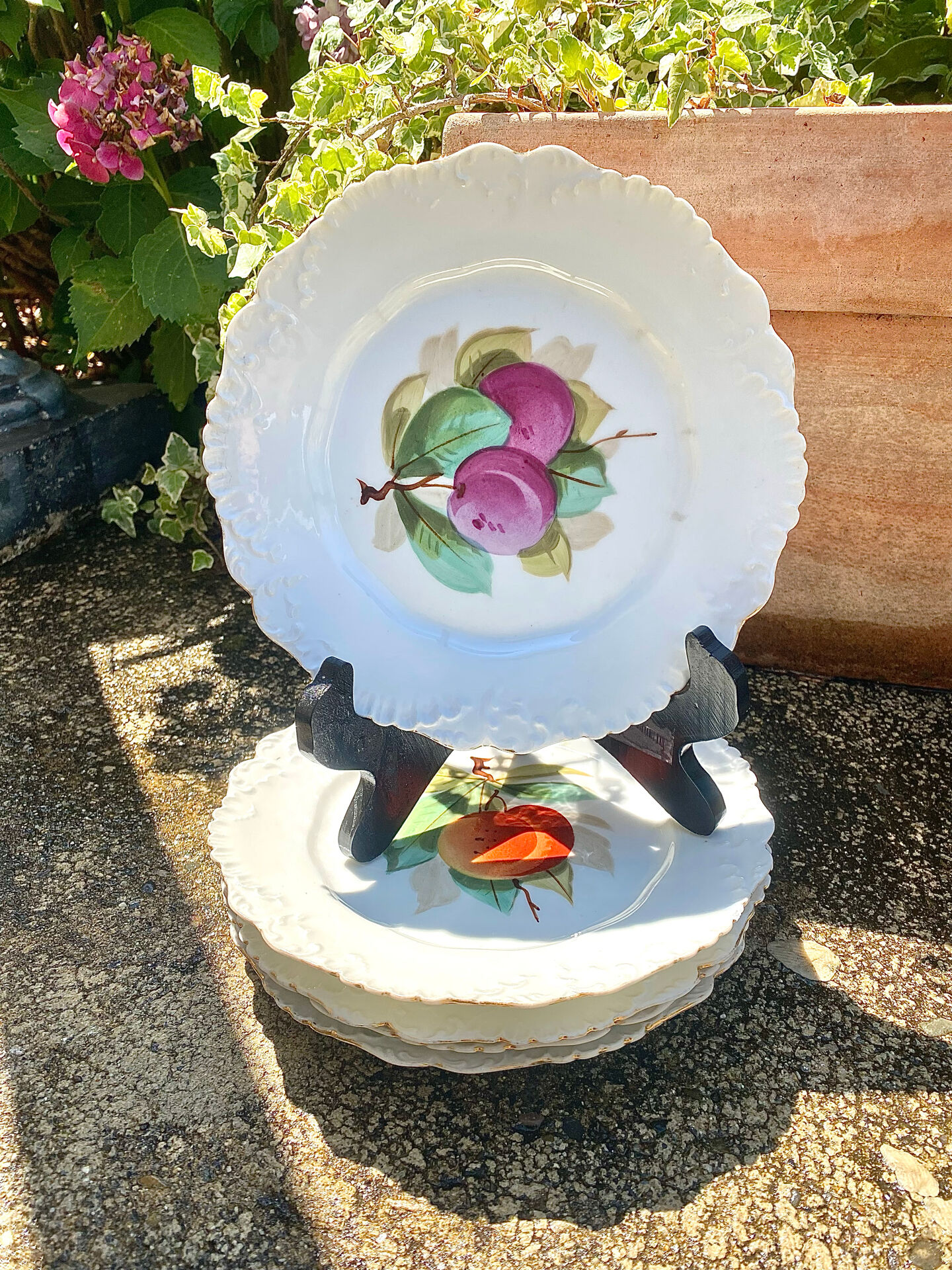 Antique plates from the late 19th century with scalloped edges and fruit decoration.