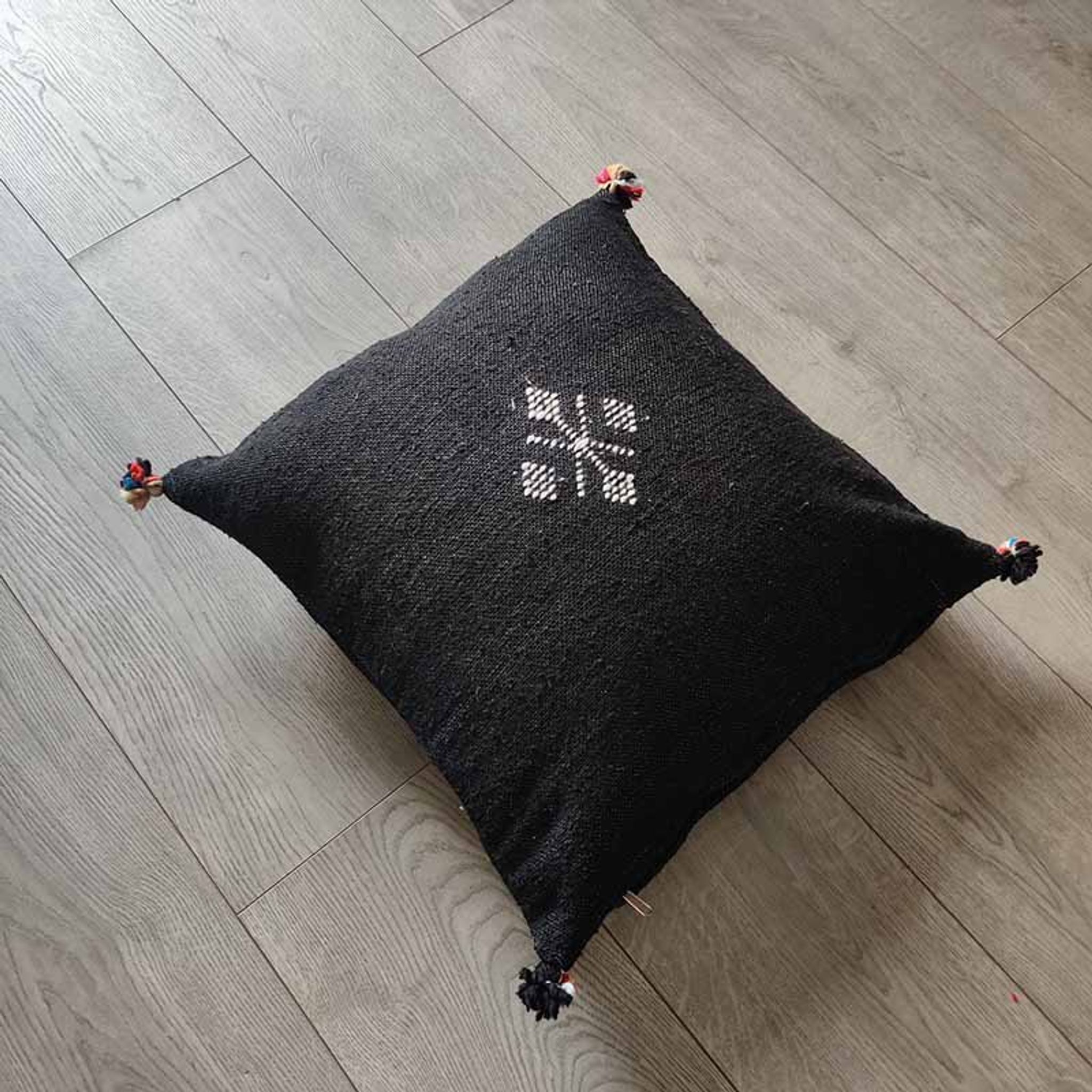 Coussin marocain noir à pompon en coton