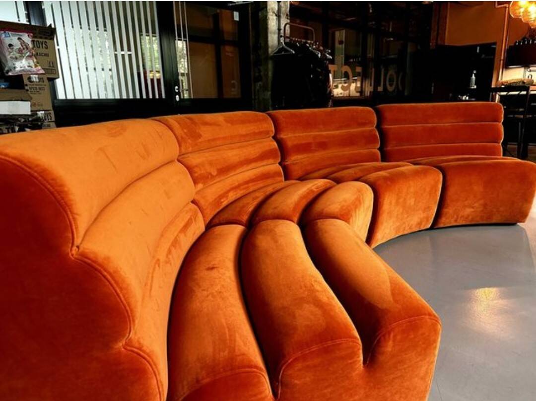 Burnt orange modular sofa for four with a futuristic design.