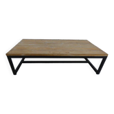 Industrial style coffee table with wooden top supported by a metal base -