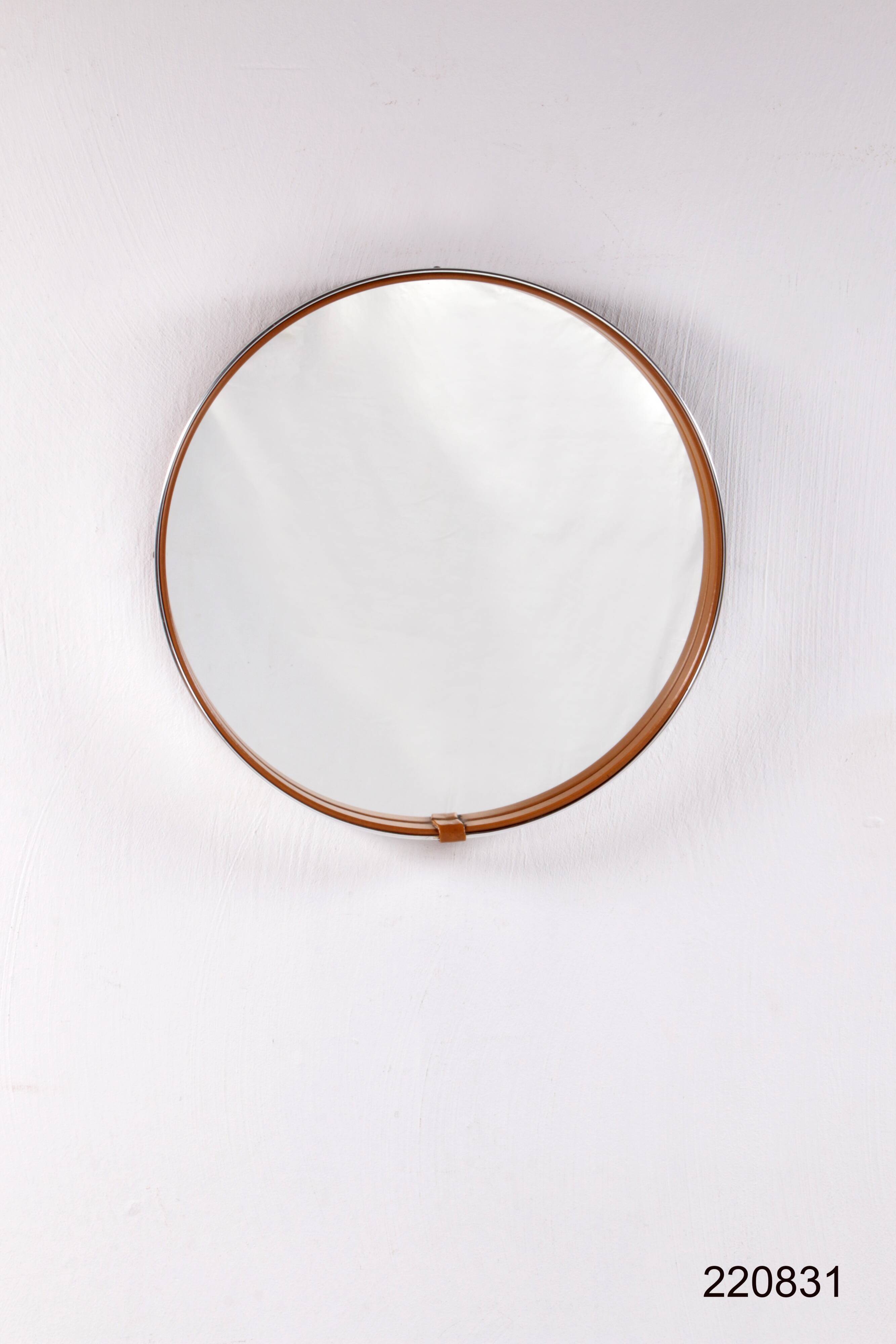 Round mirror covered with leather and chrome, made in France in the 1970s.