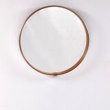 Round mirror covered with leather and chrome, made in France in the 1970s.
