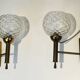 Pair of brass wall lights with glass globes. Around 1970.