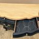 Curved commode painted in black and wood.