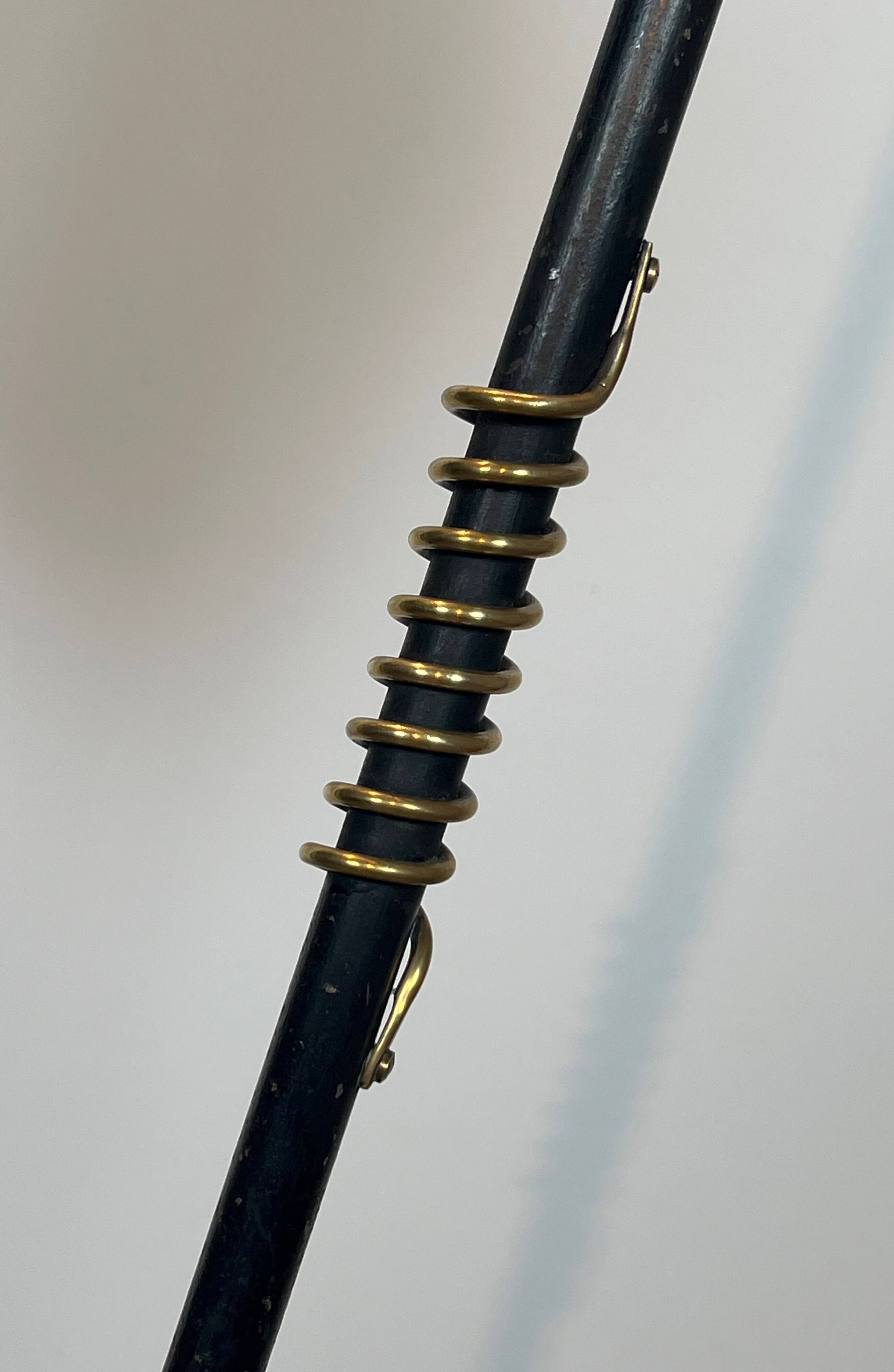 Design floor lamp in black lacquered metal and brass.