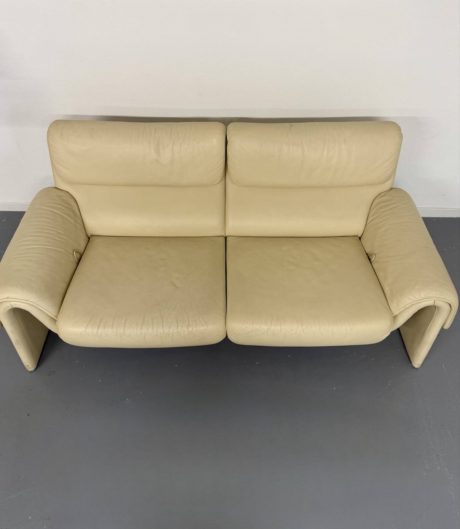 Two-seater designer sofa De Sede DS-2011 in cream leather with adjustable backrest.