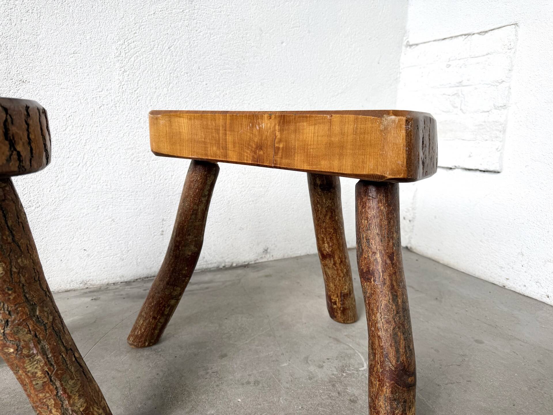 Set of three rustic solid wood tripod stools.