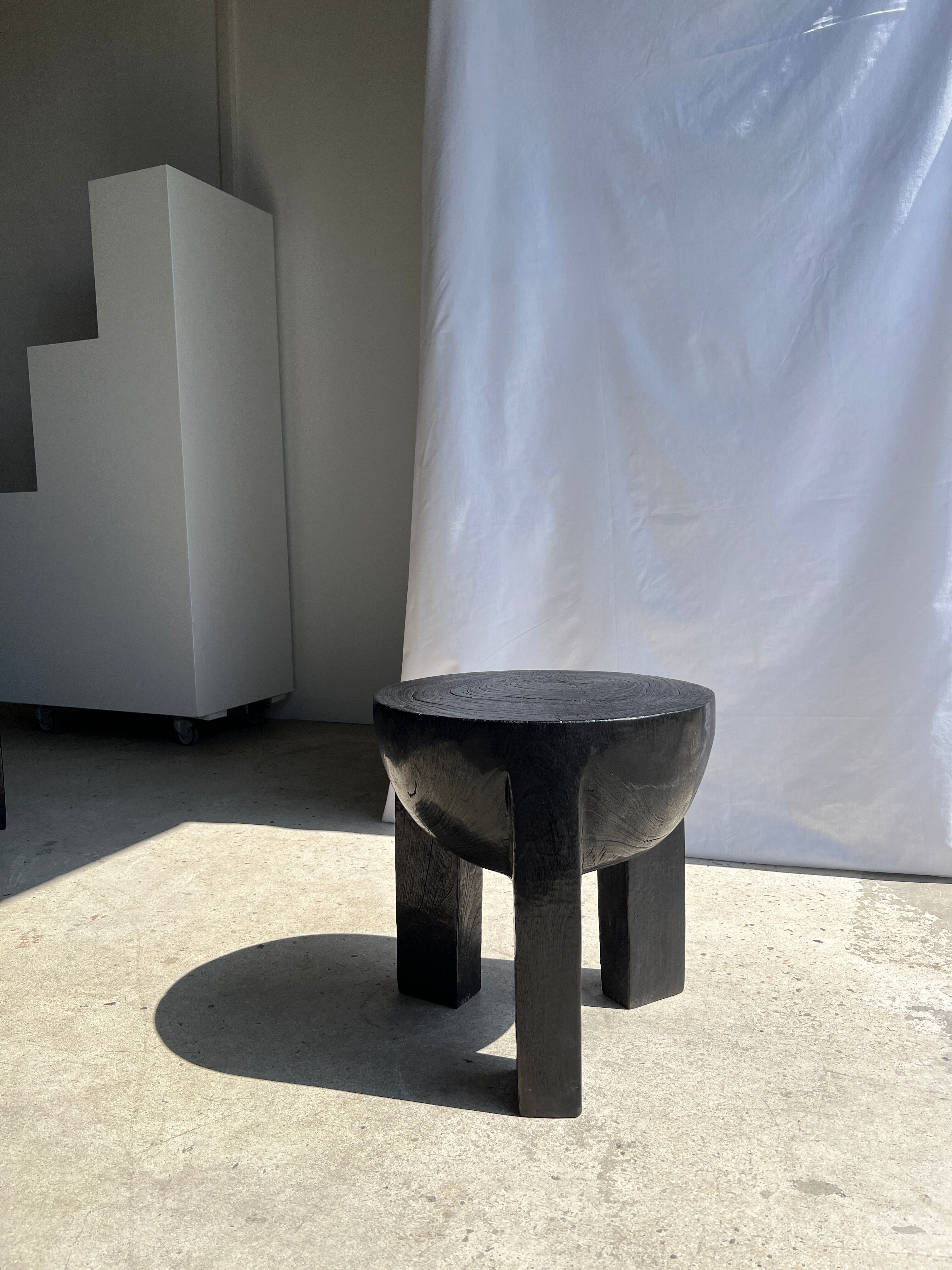 Black mango wood tripod side table with a semi-spherical top, height: 45 cm, diameter: 44 cm.