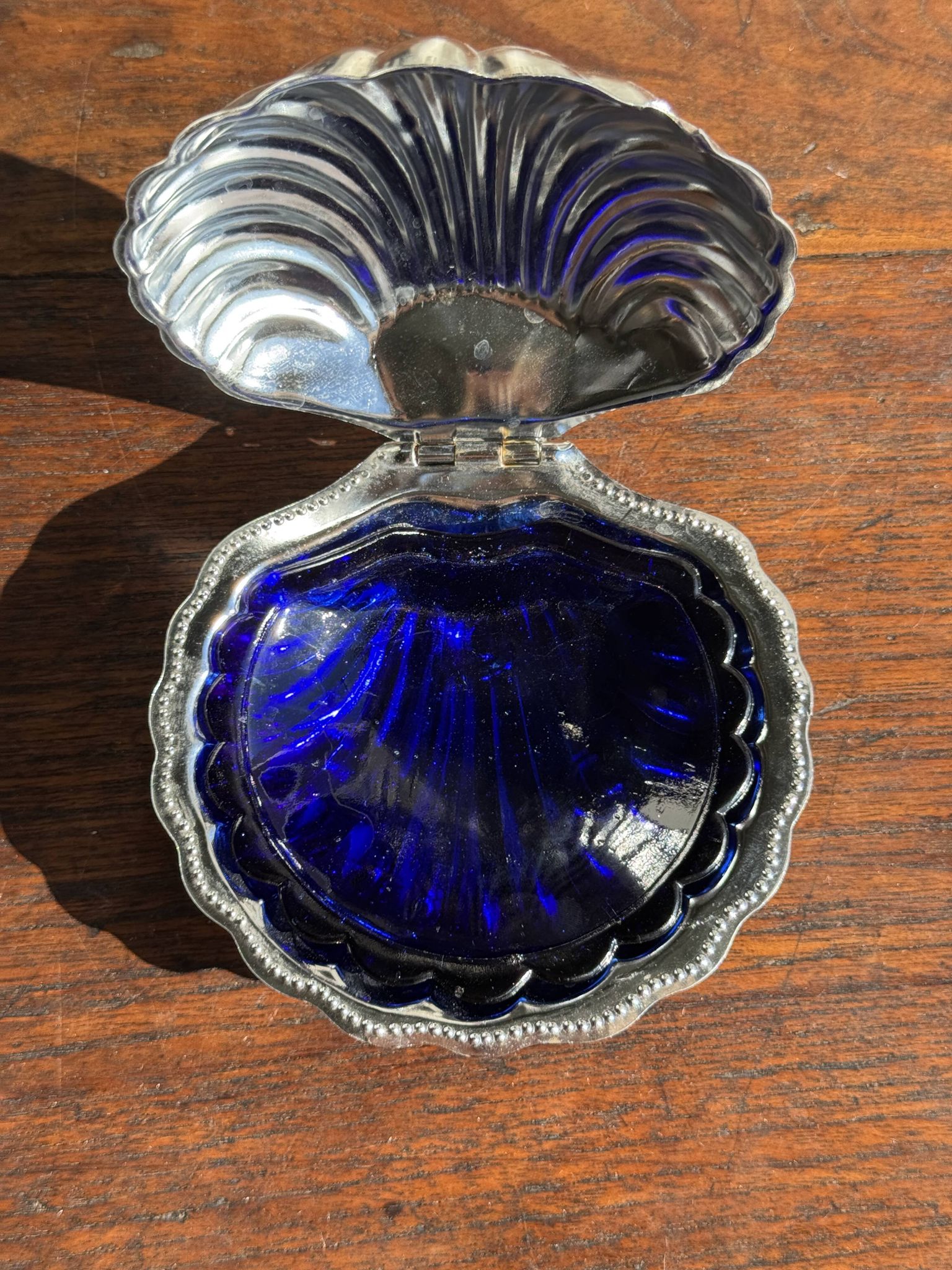 Vintage silver-plated shell butter dish with blue bowl.