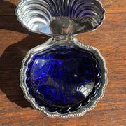 Vintage silver-plated shell butter dish with blue bowl.