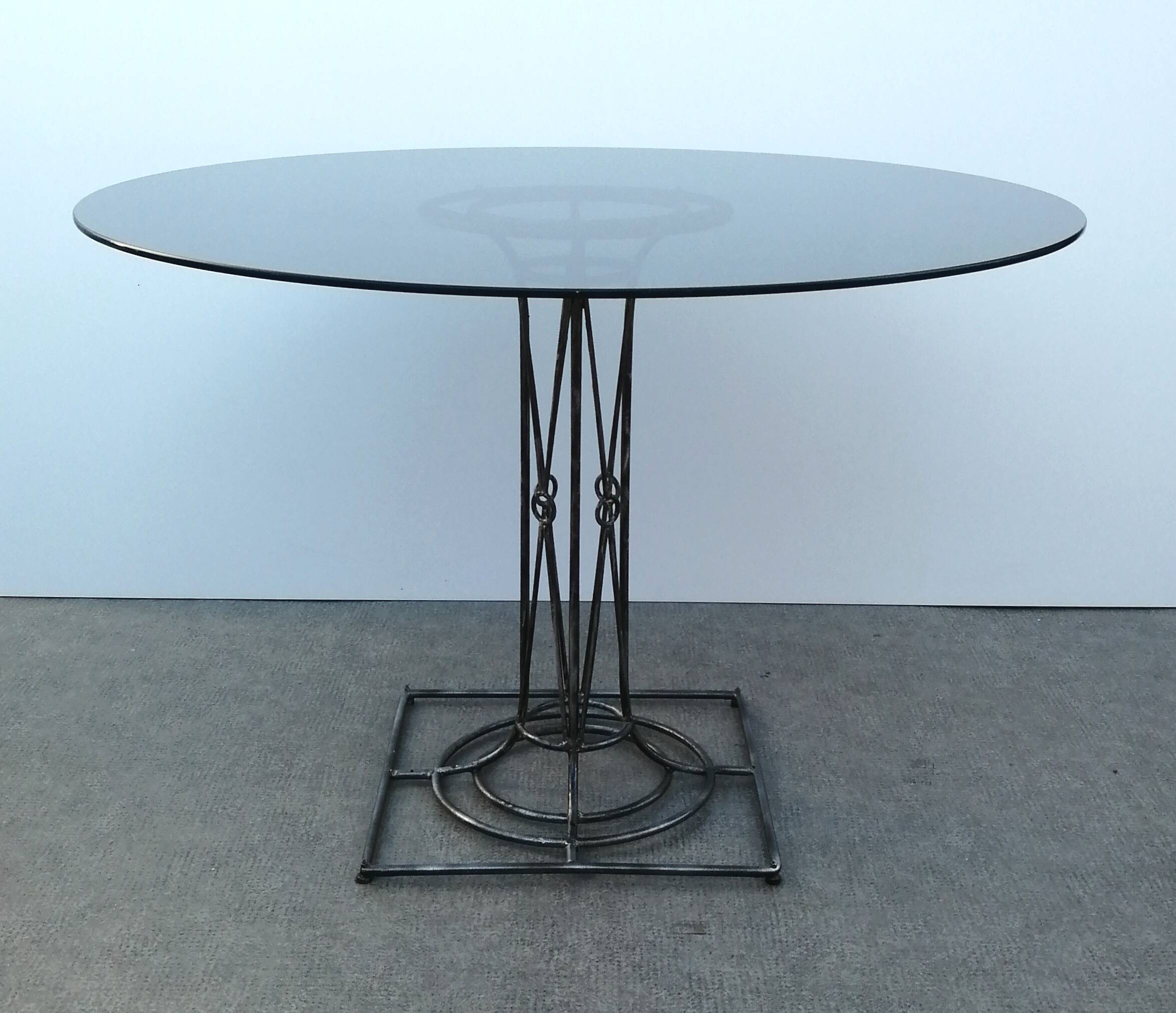 Wrought iron dining table with its round smoked glass top, vintage 1980
