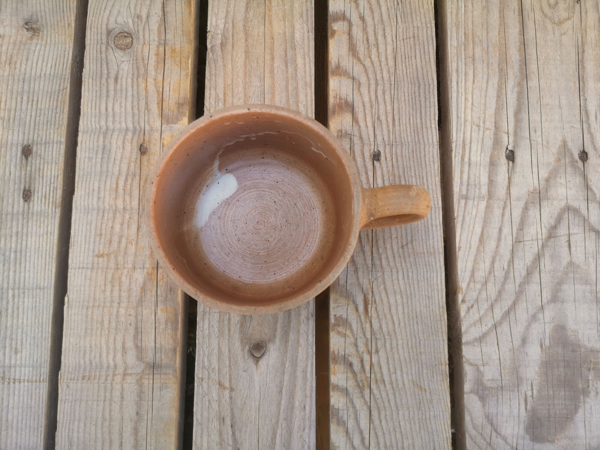 Brown sandstone cup with white spots