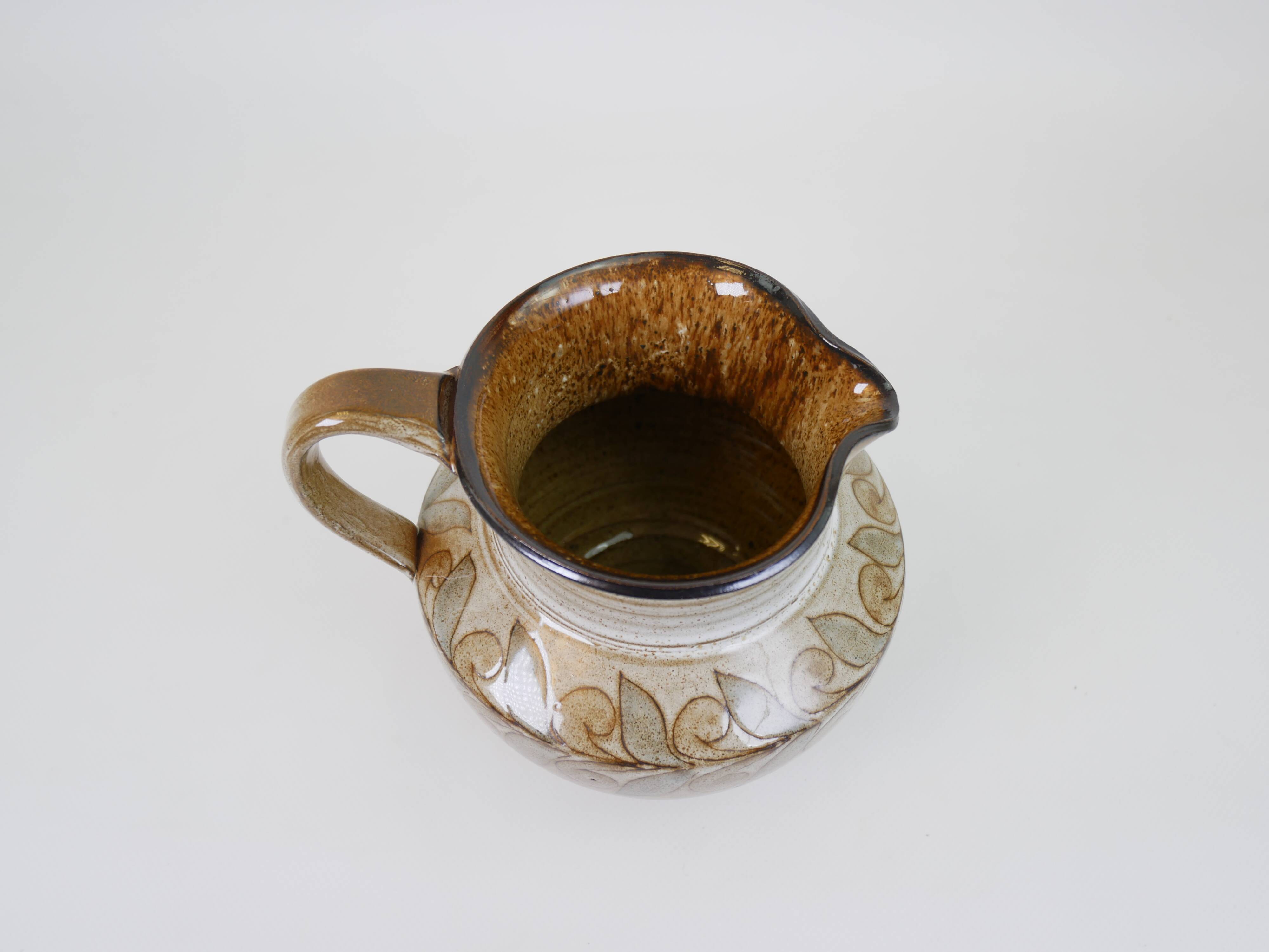 Glazed ceramic jug with plant decoration