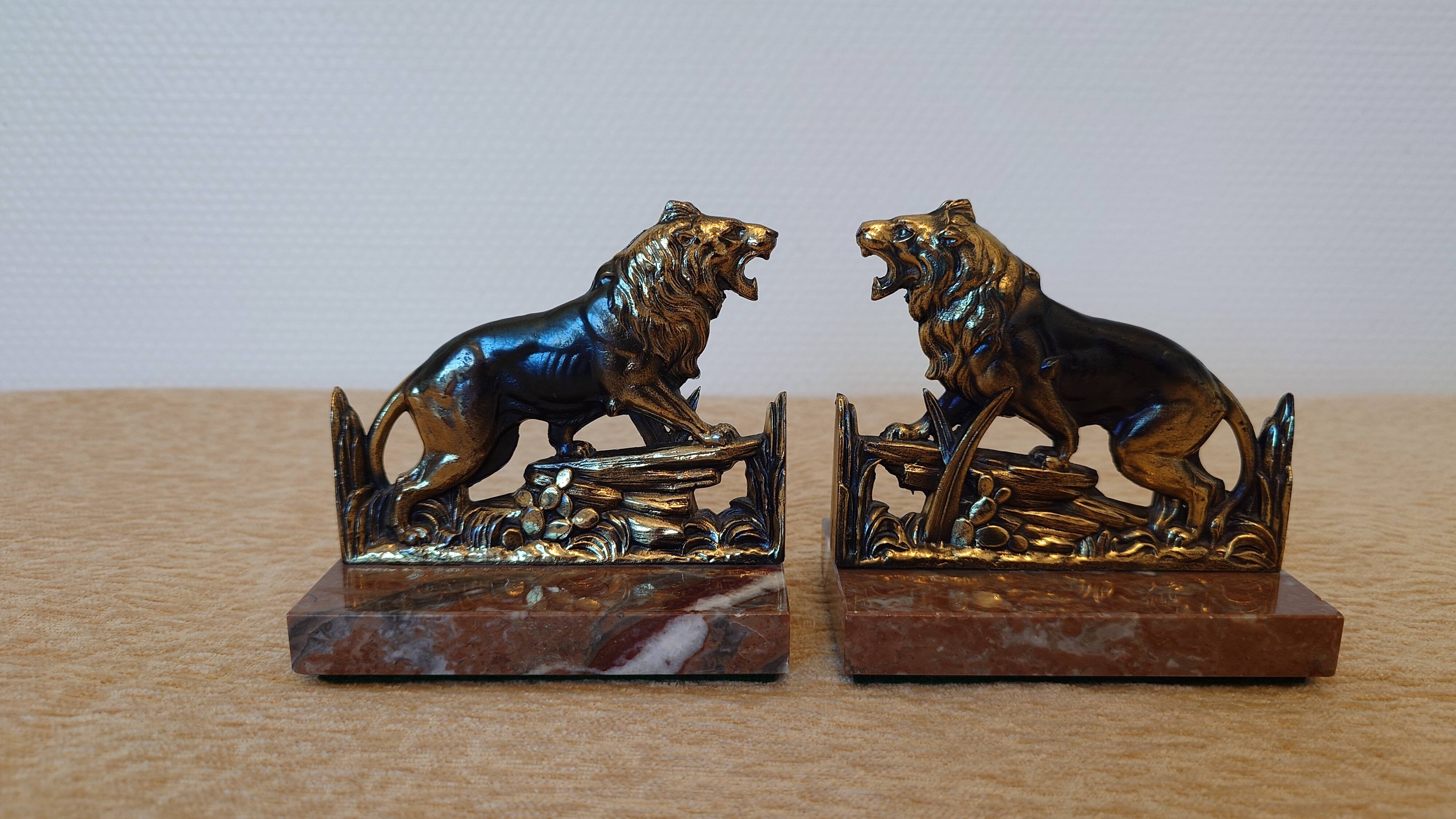 Small roaring lion bookends in patinated metal on a marble base.