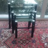3 nesting tables in black metal with smoked glass tops.