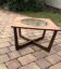 Round glass coffee table with a gold border and brown teak structure, Astro 1960s style.