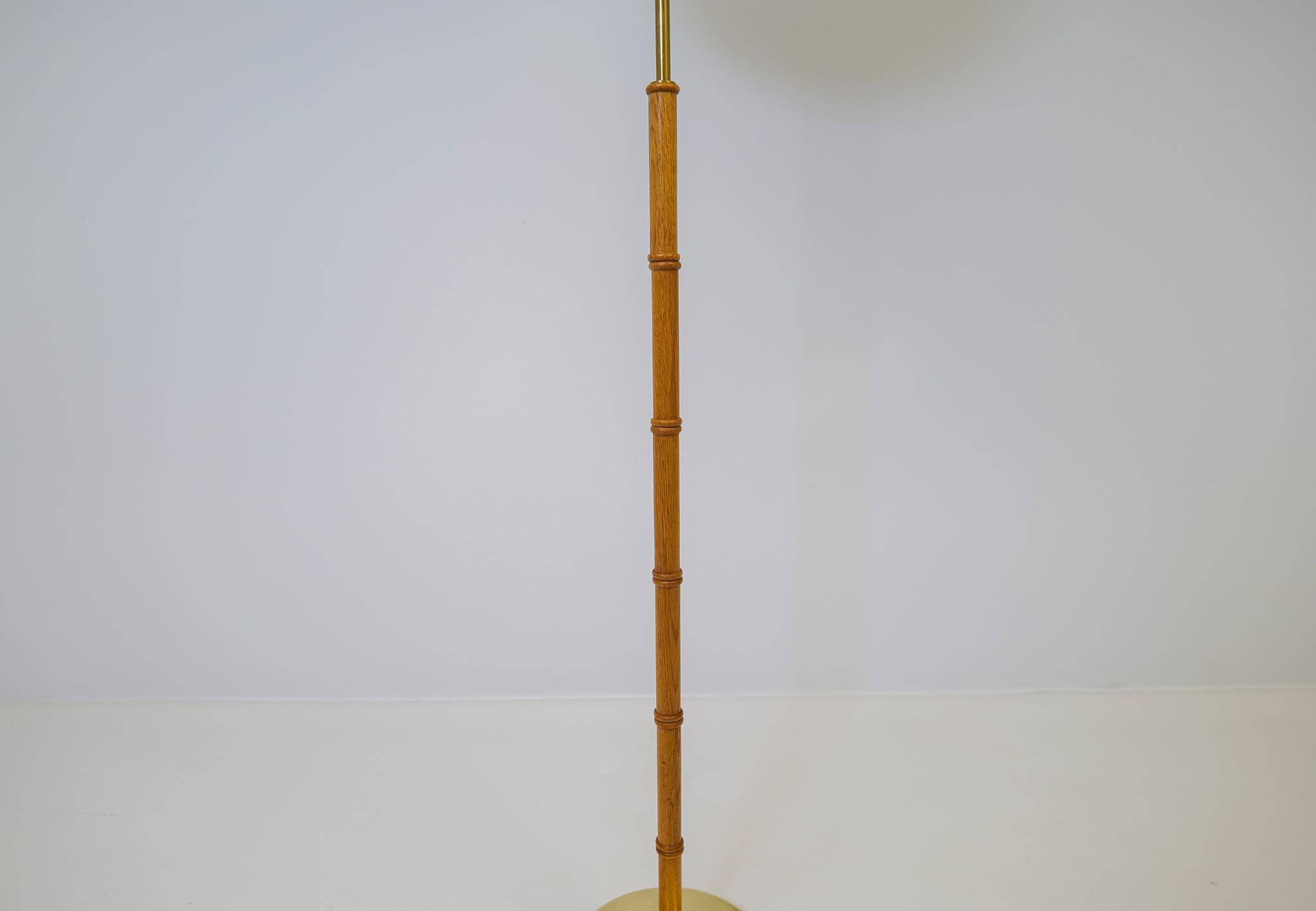 Mid-century floor lamp in brass and oak by Falkenbergs Belysning, Sweden, 1960s.