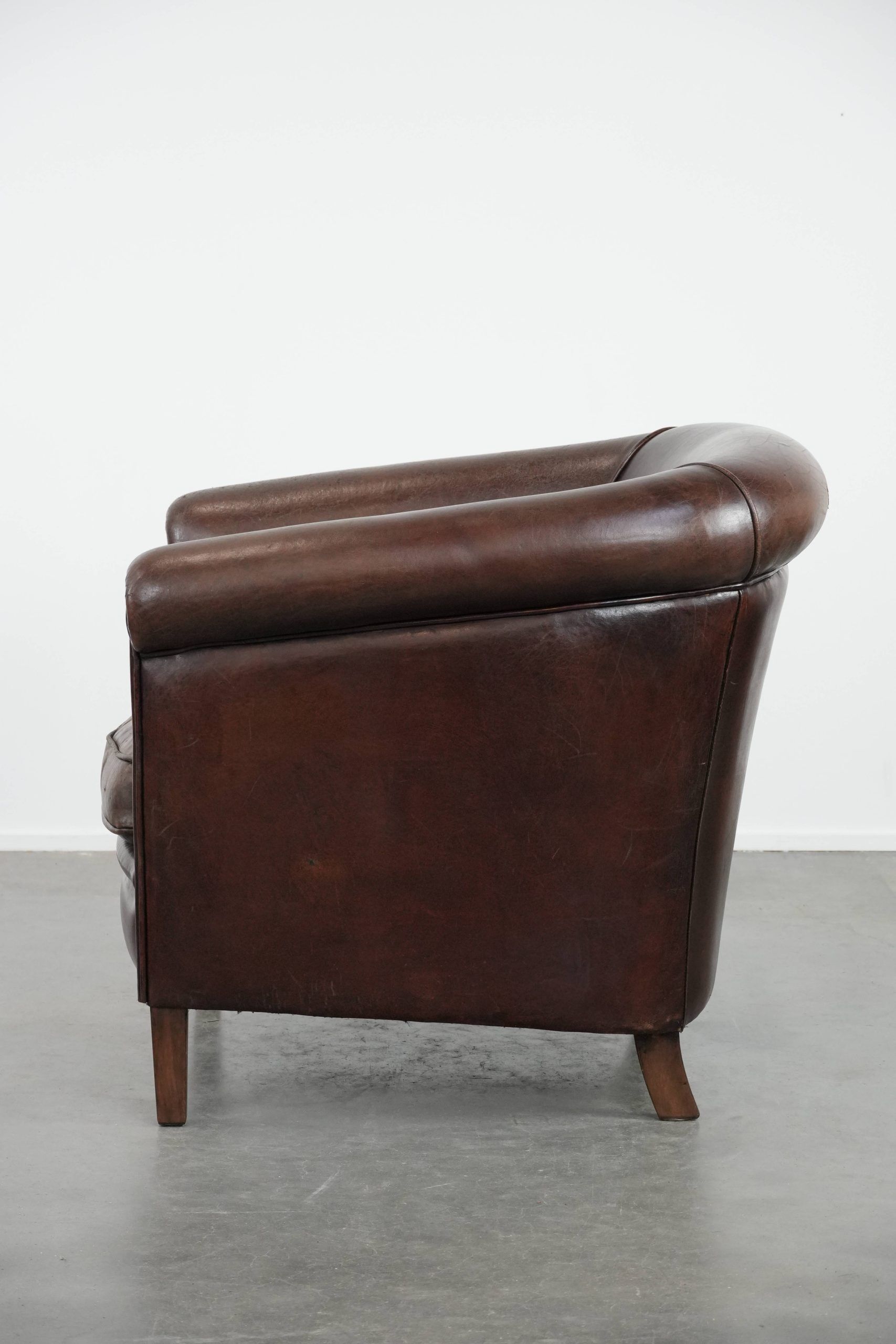 Stylish and sturdy dark brown club armchair made of sheepskin leather