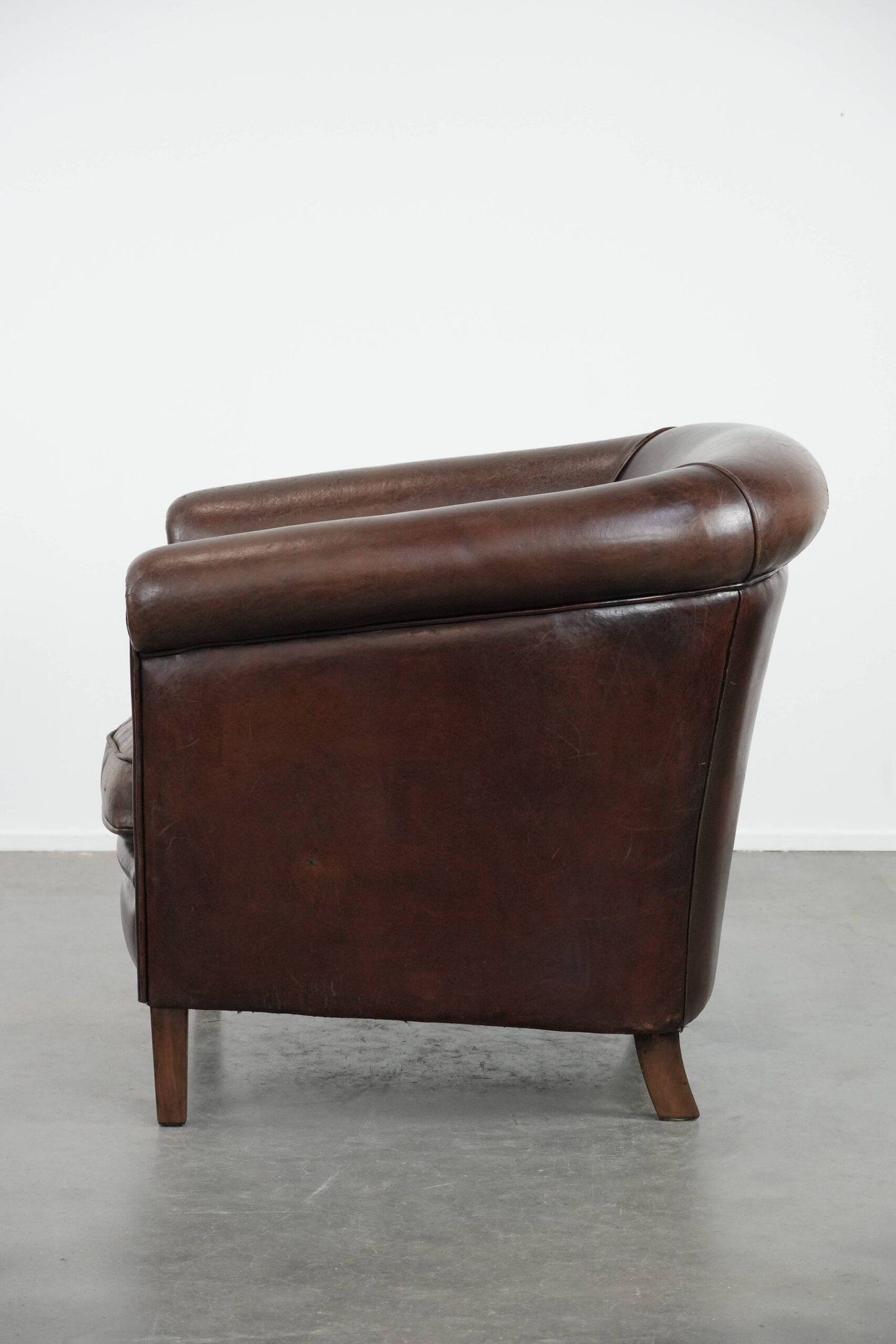 Stylish and sturdy dark brown club armchair made of sheepskin leather