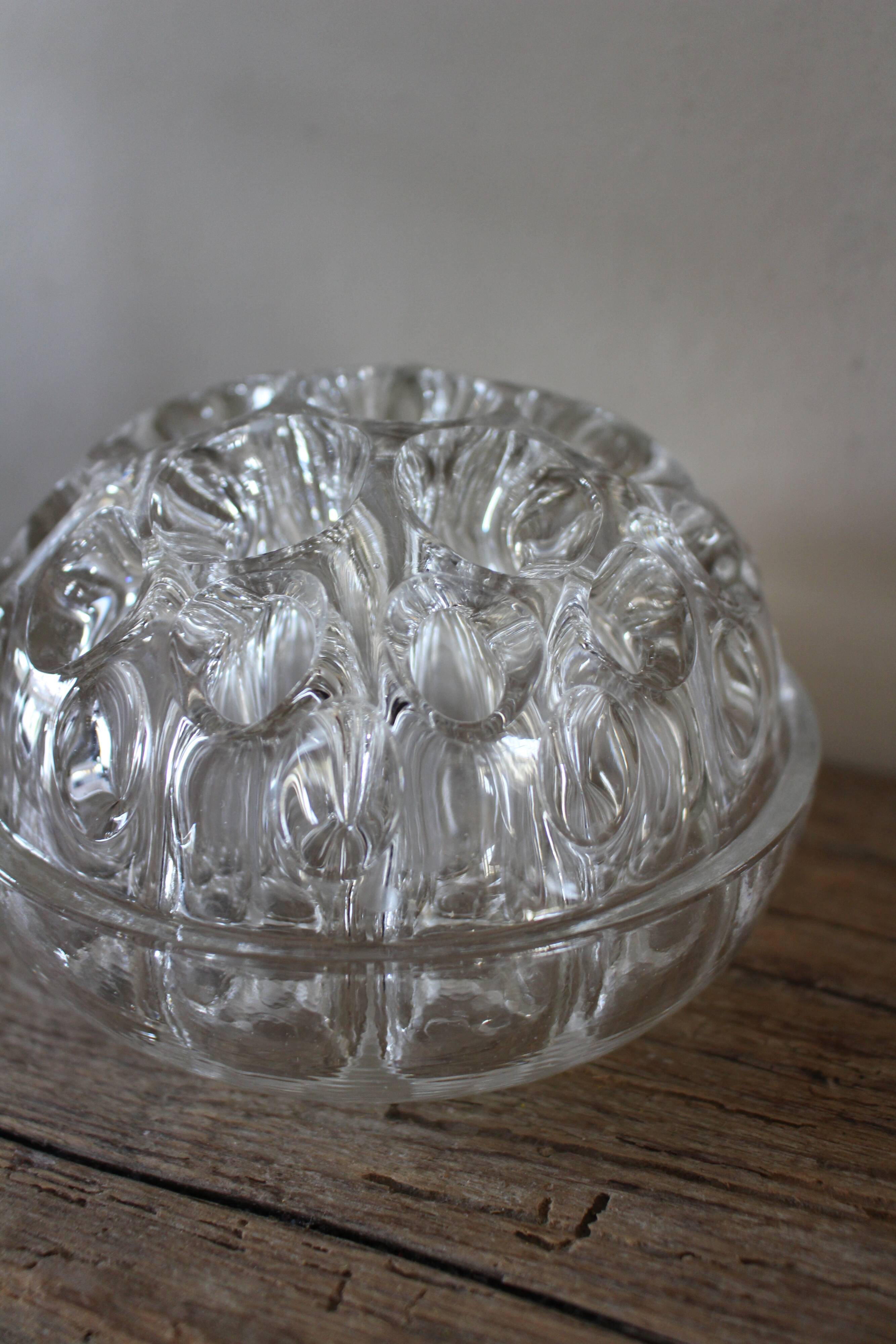 Large round glass flower frog vase with 19 holes.