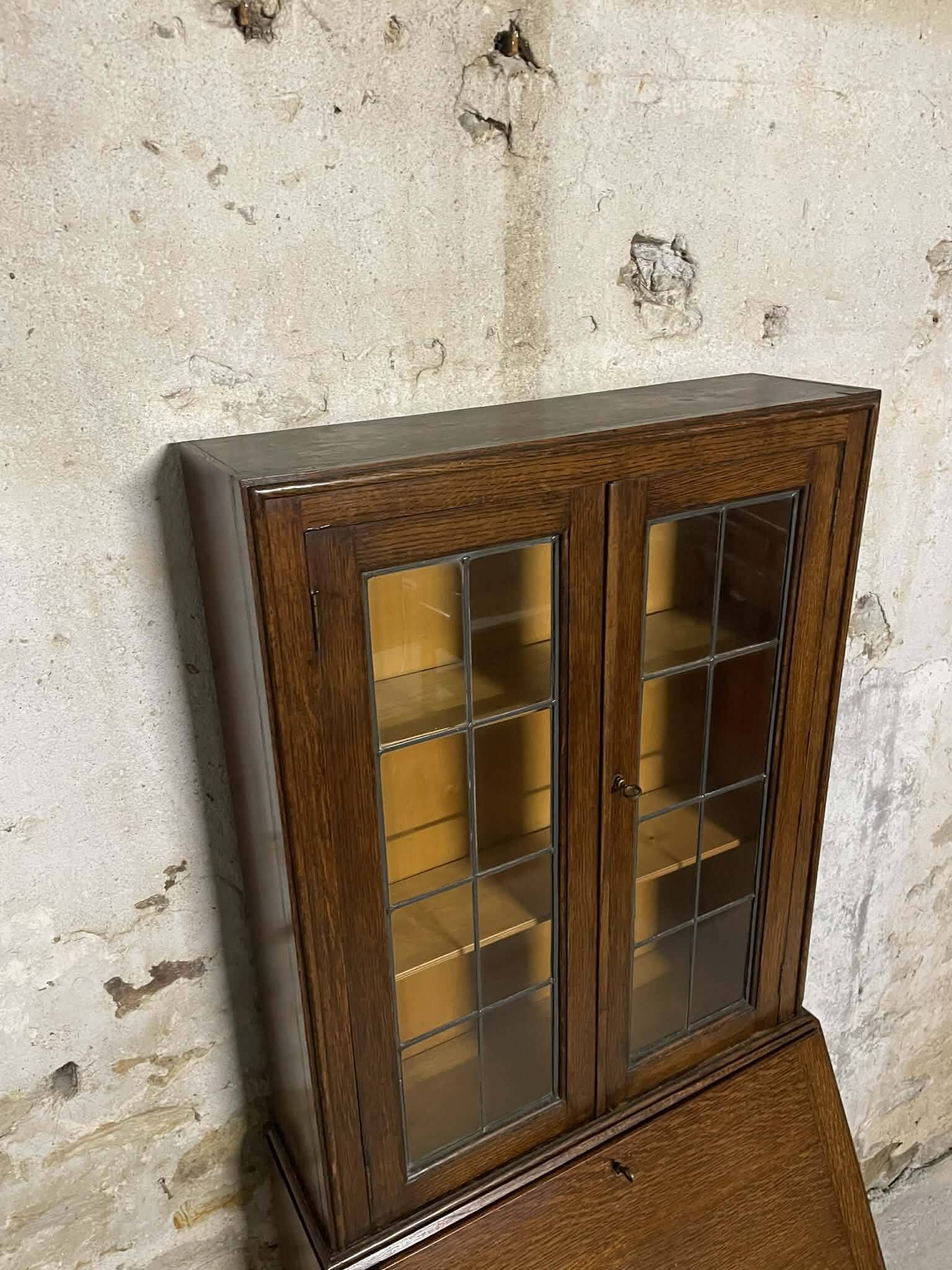 Oak display secretary cabinet with drop-down front, two sections.