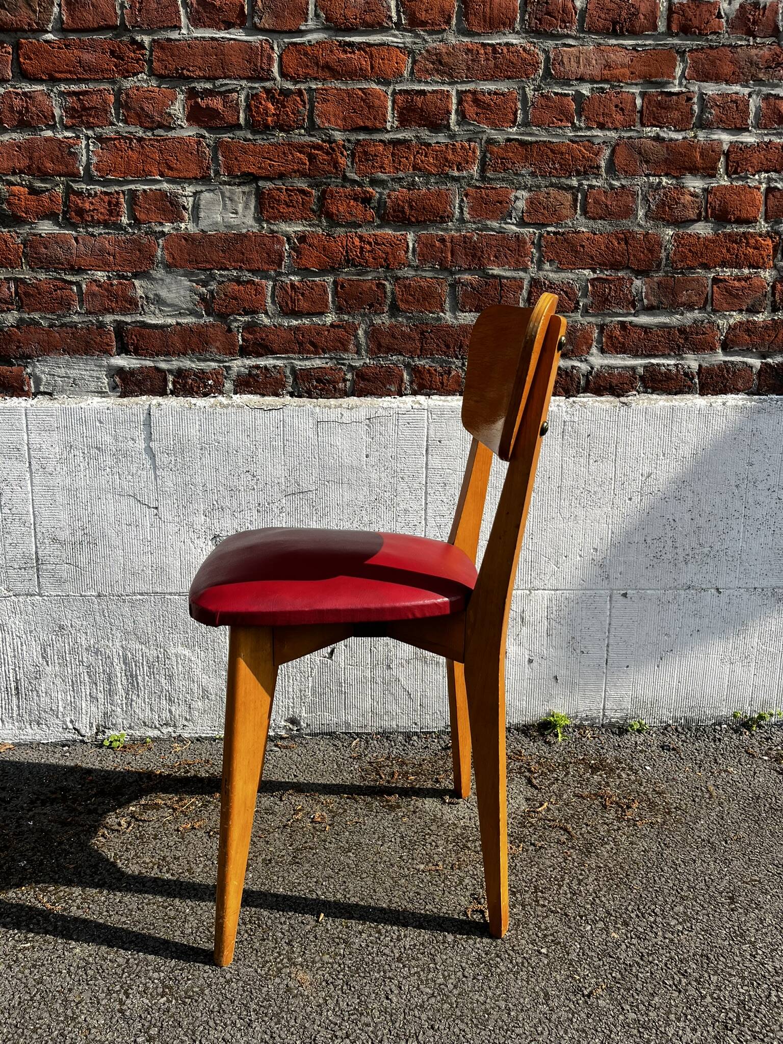 Set of 4 vintage bistro chairs in wood and red faux leather, with splayed legs.