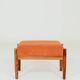 Vintage armchair and footrest in orange corduroy.
