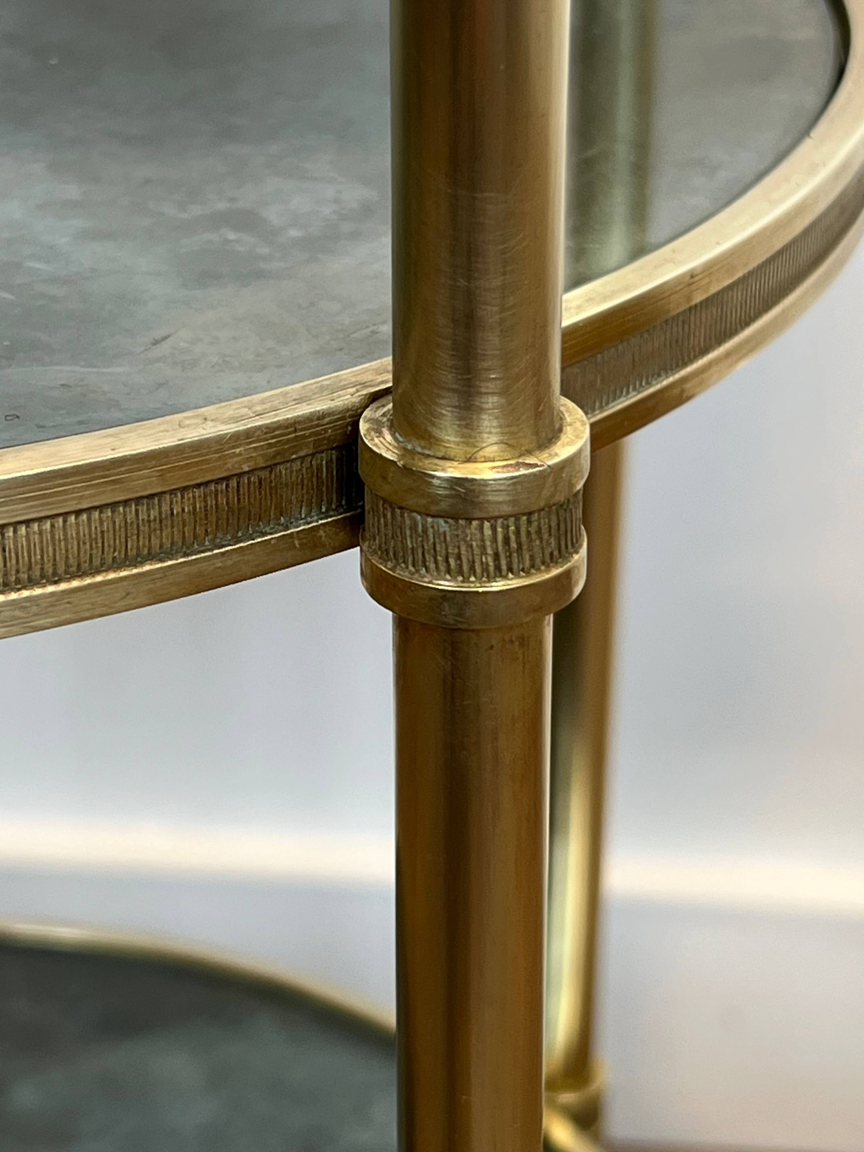 Round bronze side table with triple shelves of églomisé mirrors from Maison Baguès