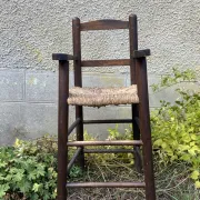 Vintage wooden children's high chair with straw.
