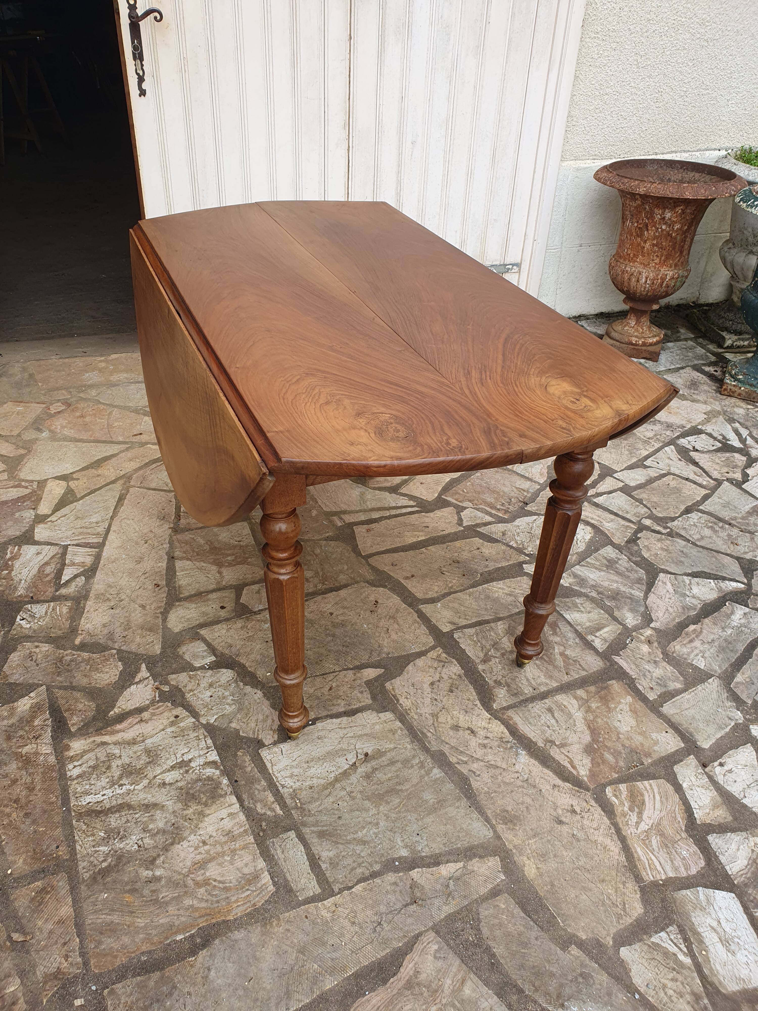Round extending table in solid walnut, 19th century