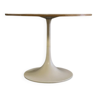 Mid-century round tulip dining table with a wooden top, vintage 1970s design.