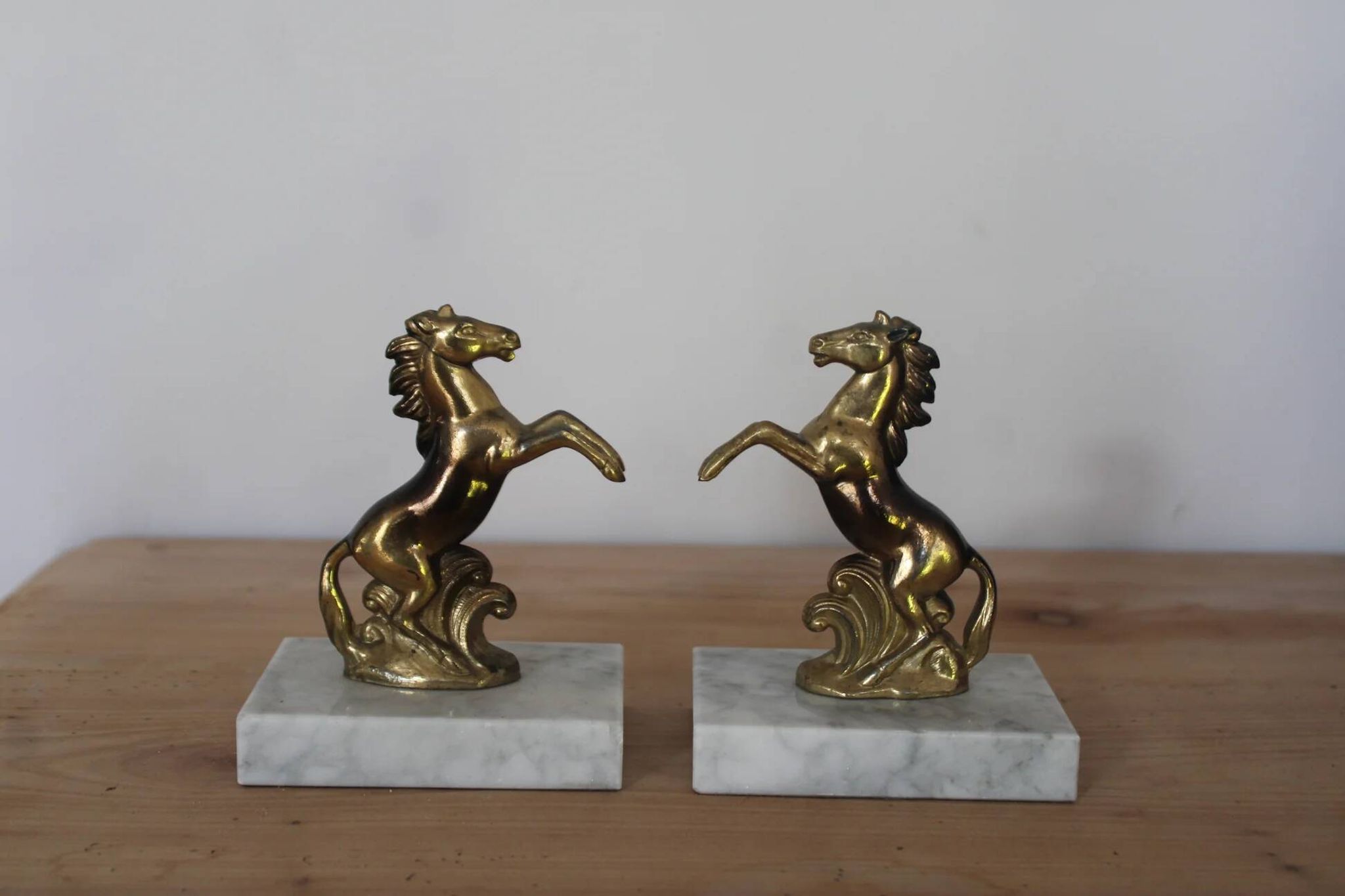 Pair of vintage bookends with rearing horses in gilded metal on marble bases.