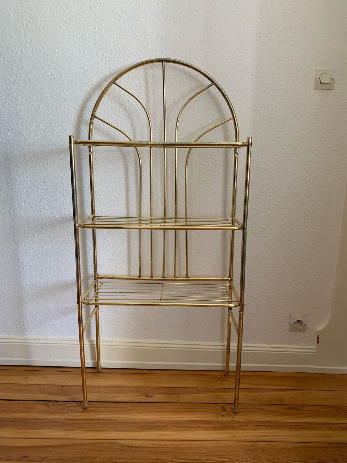 Gilded metal grid shelf in the shape of a vaulted arch