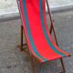 Vintage folding wooden deck chair with red and green striped canvas from the 1970s.