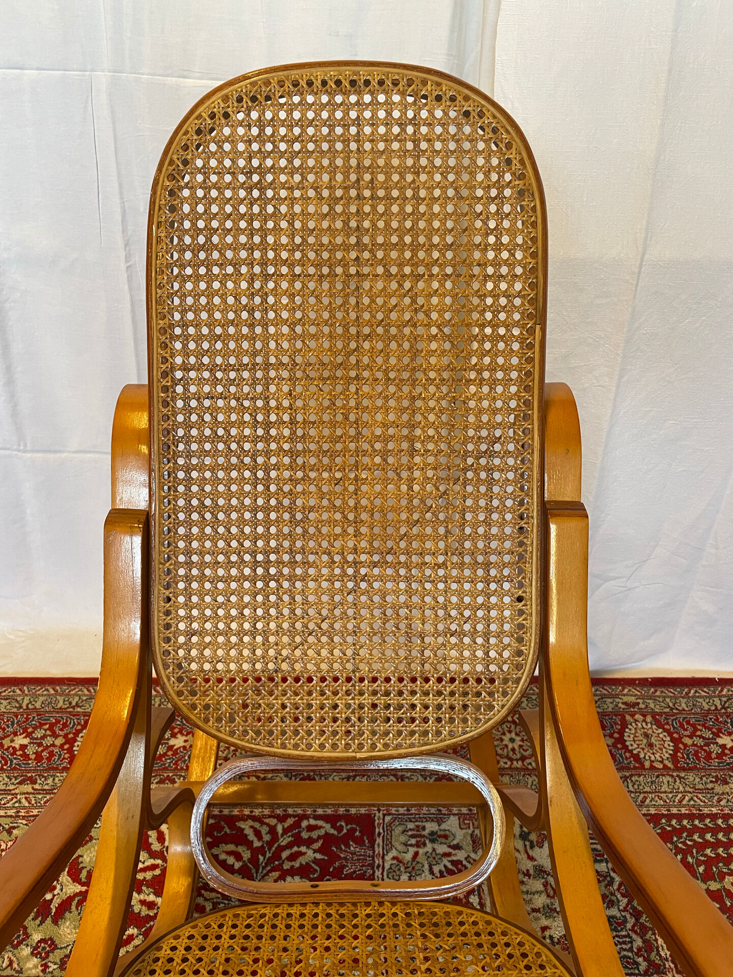 Antique rocking chair in curved wood and caning.