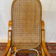 Antique rocking chair in curved wood and caning.